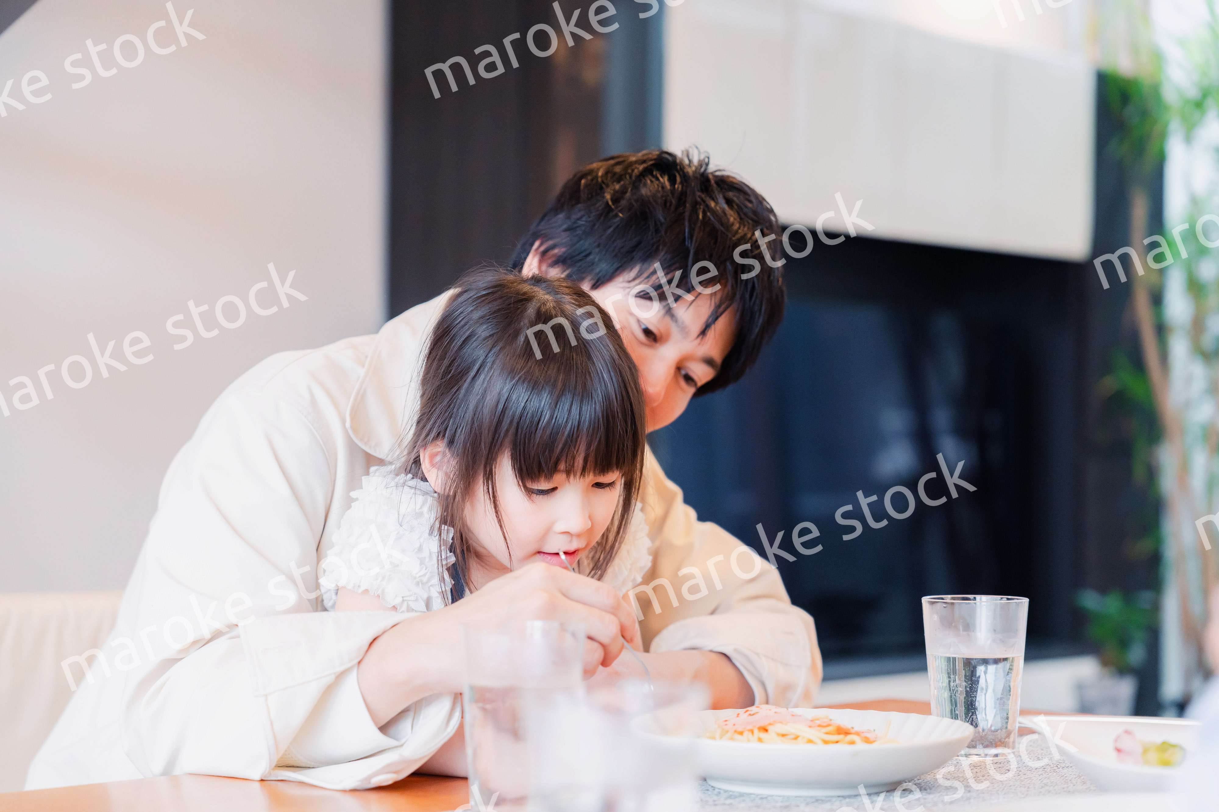 パパと一緒にご飯を食べる小さな女の子