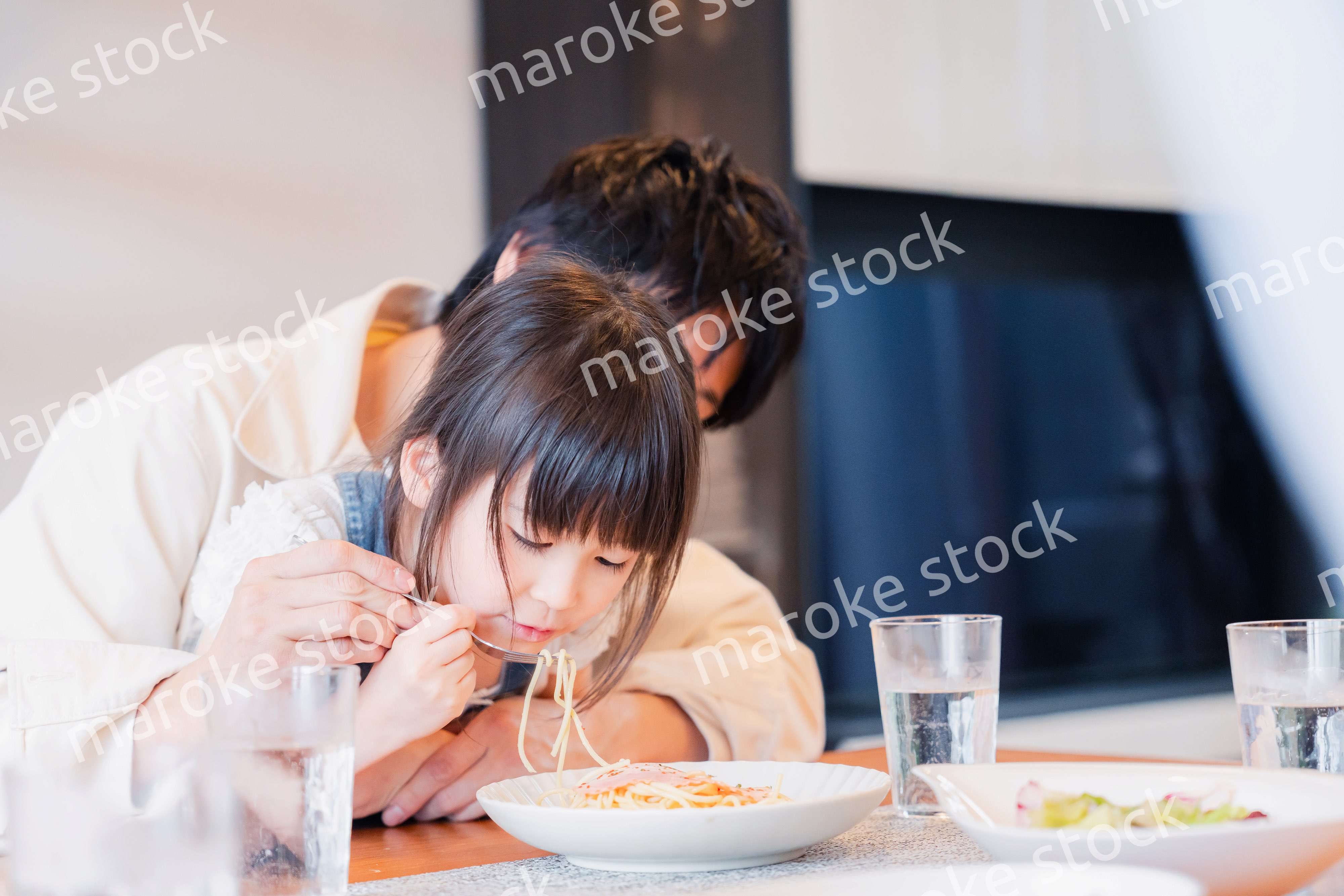 パパと一緒にご飯を食べる小さな女の子