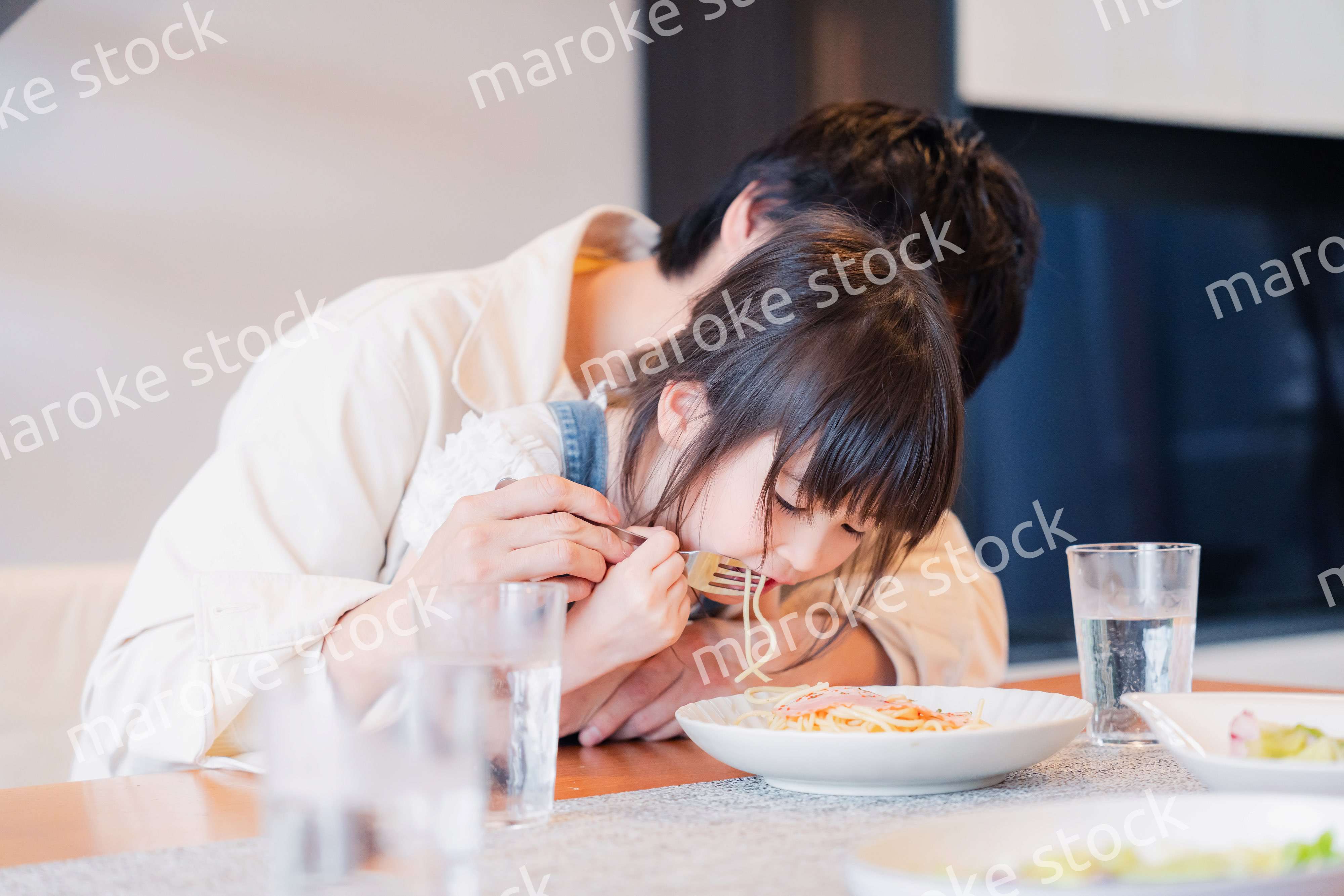 パパと一緒にご飯を食べる小さな女の子