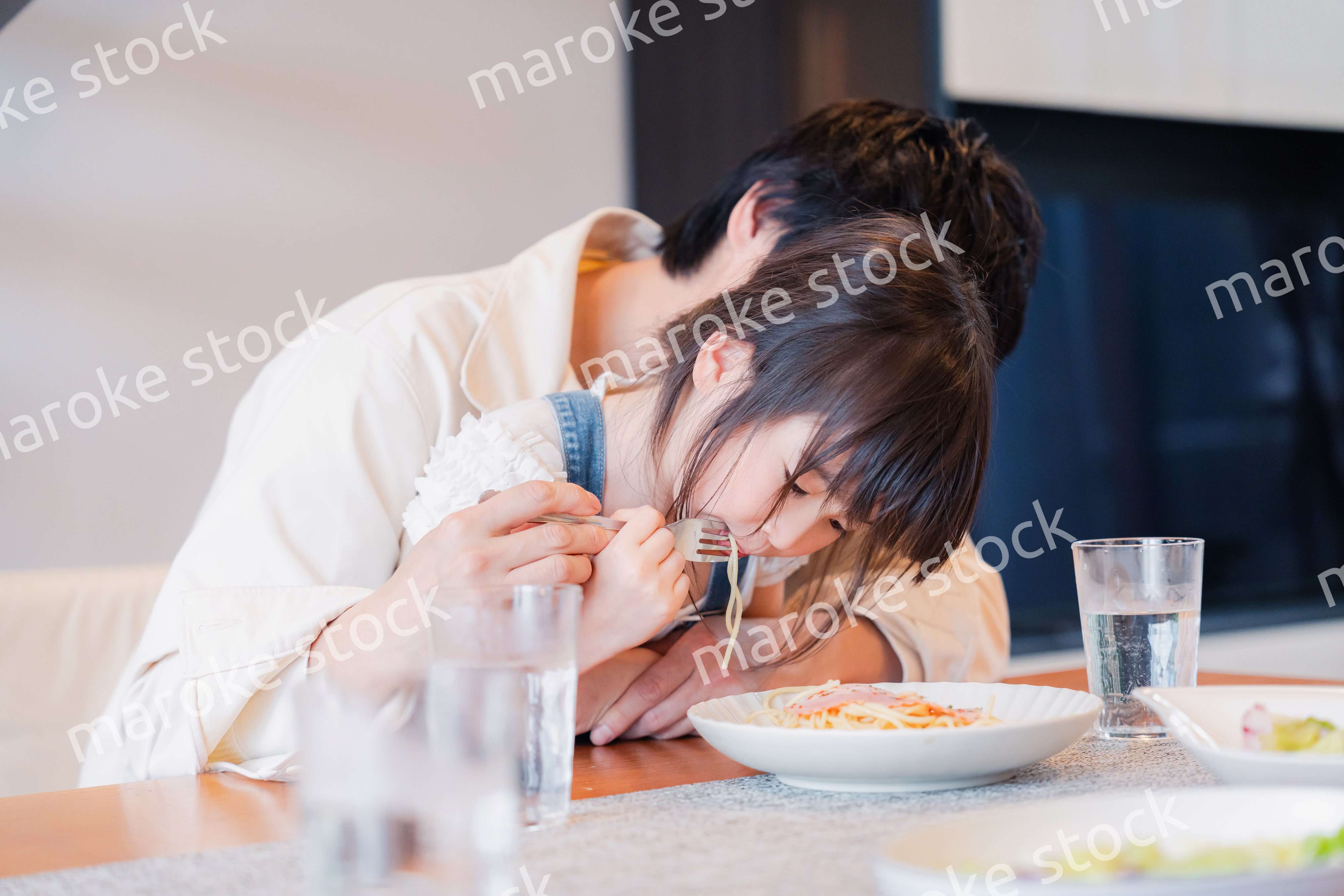 パパと一緒にご飯を食べる小さな女の子