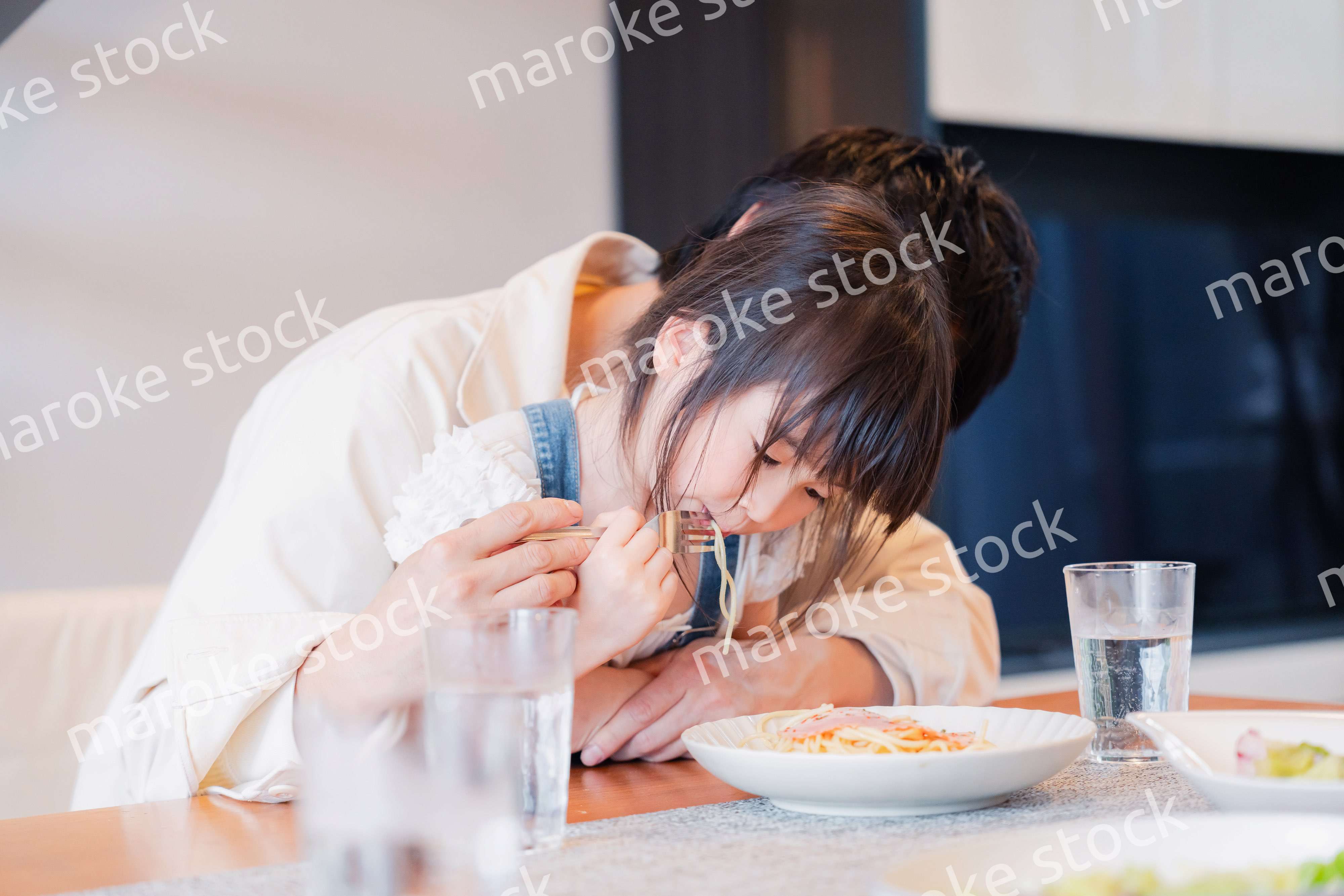 パパと一緒にご飯を食べる小さな女の子