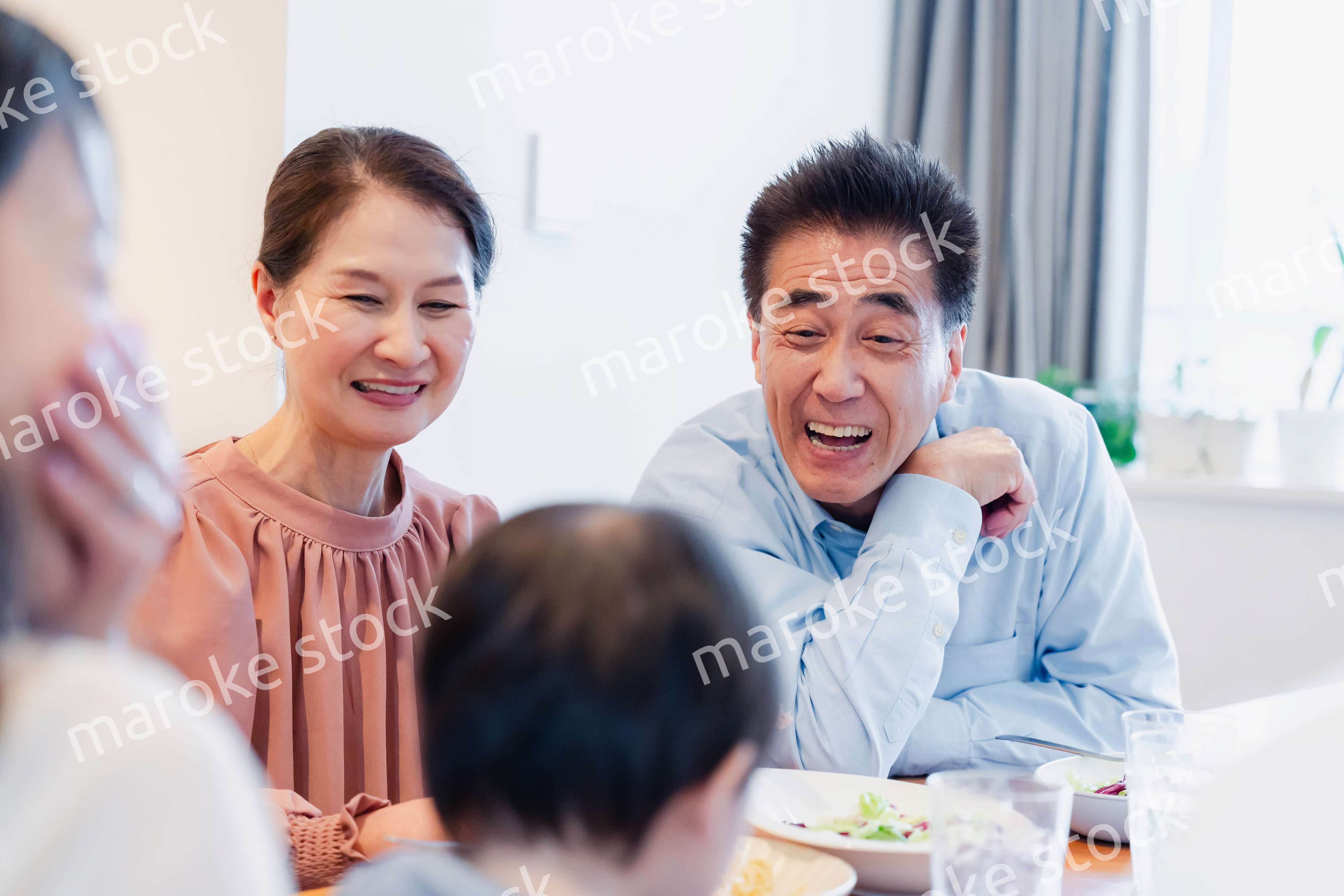 孫たちと一緒に楽しくごはんを食べる高齢の夫婦