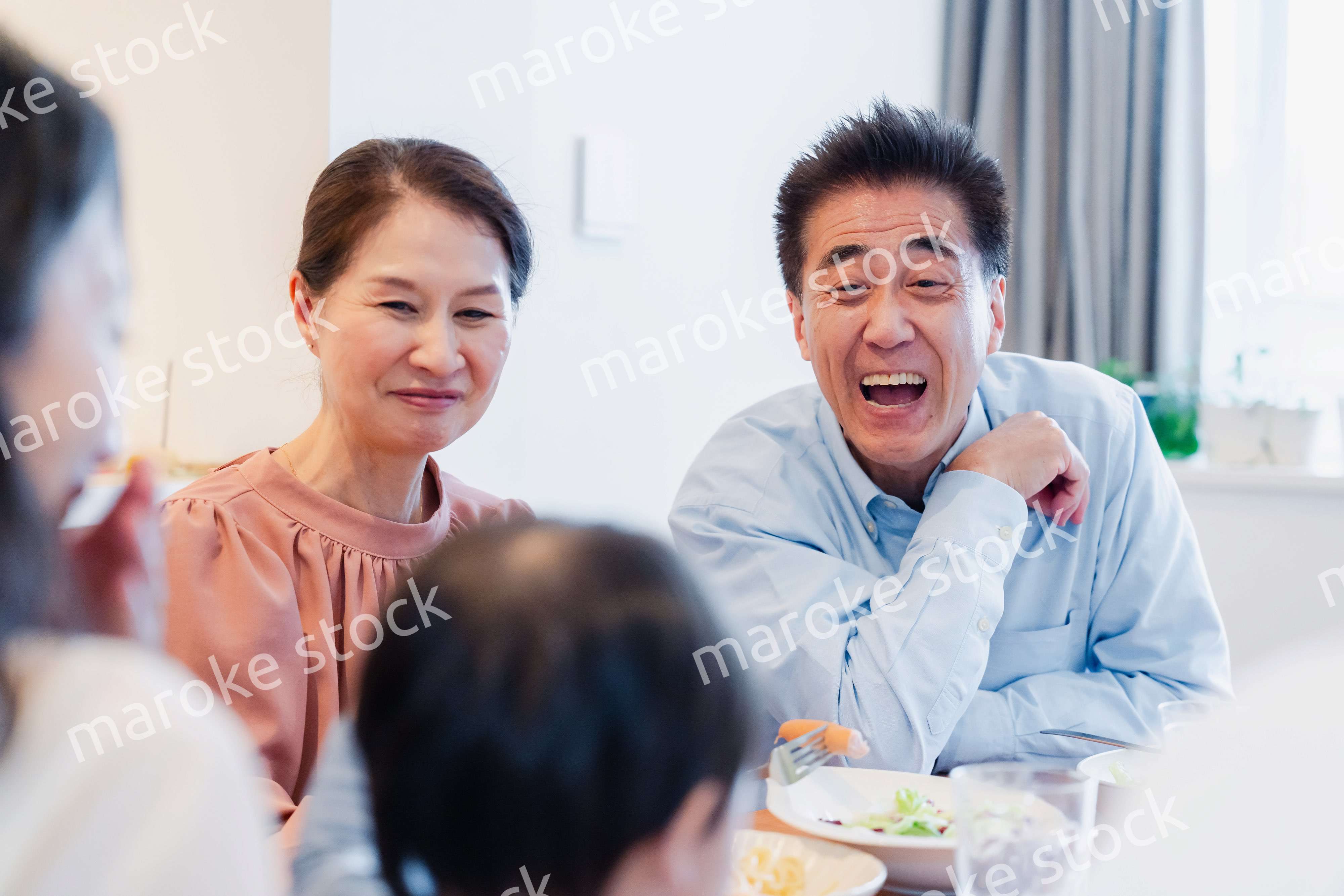 孫たちと一緒に楽しくごはんを食べる高齢の夫婦