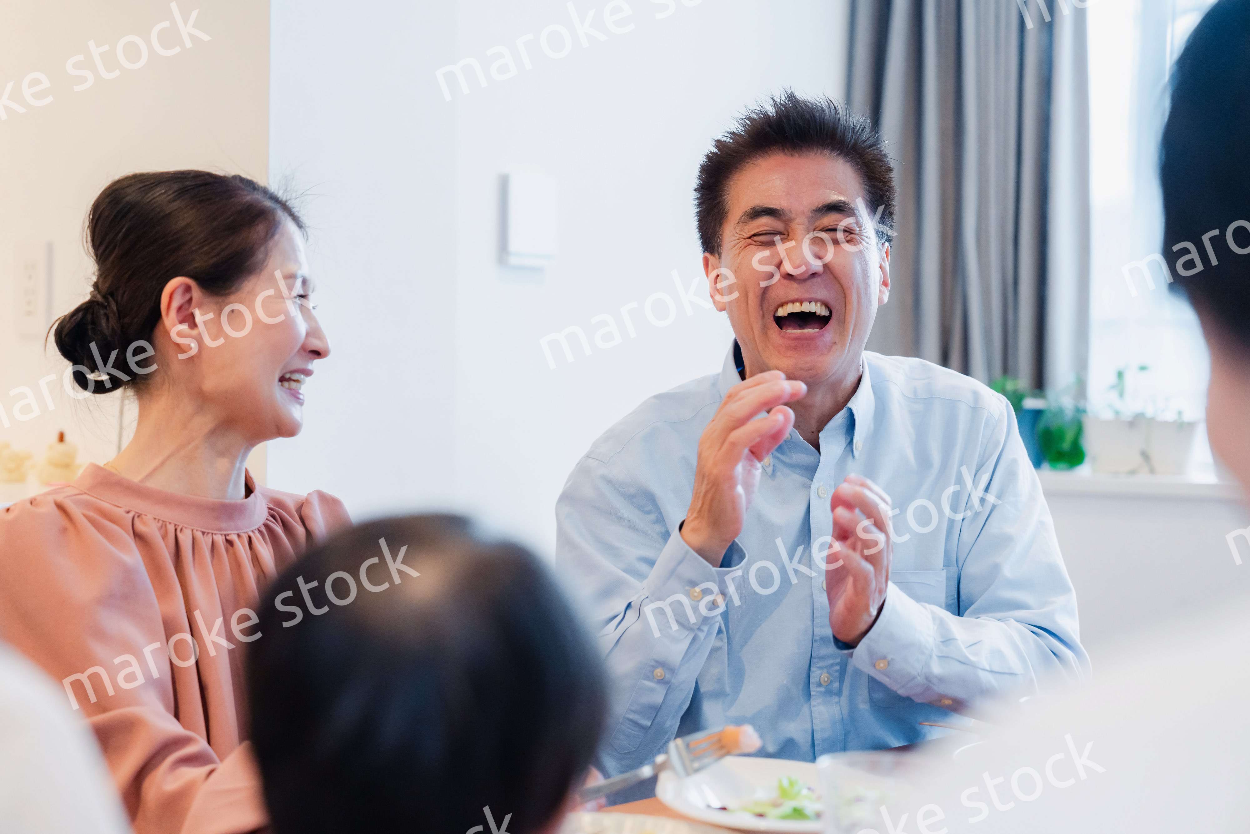 孫たちと一緒に楽しくごはんを食べる高齢の夫婦