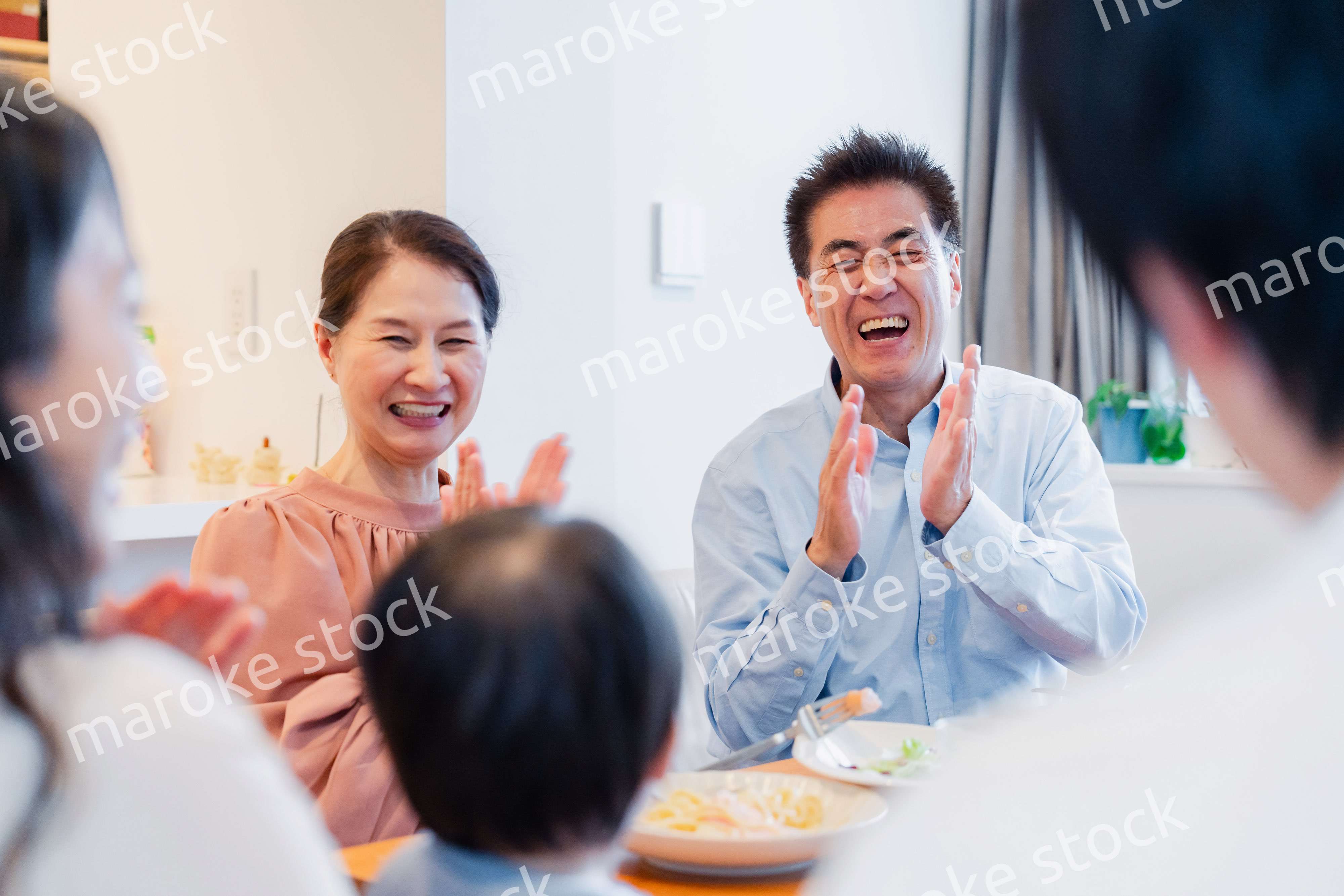 孫たちと一緒に楽しくごはんを食べる高齢の夫婦