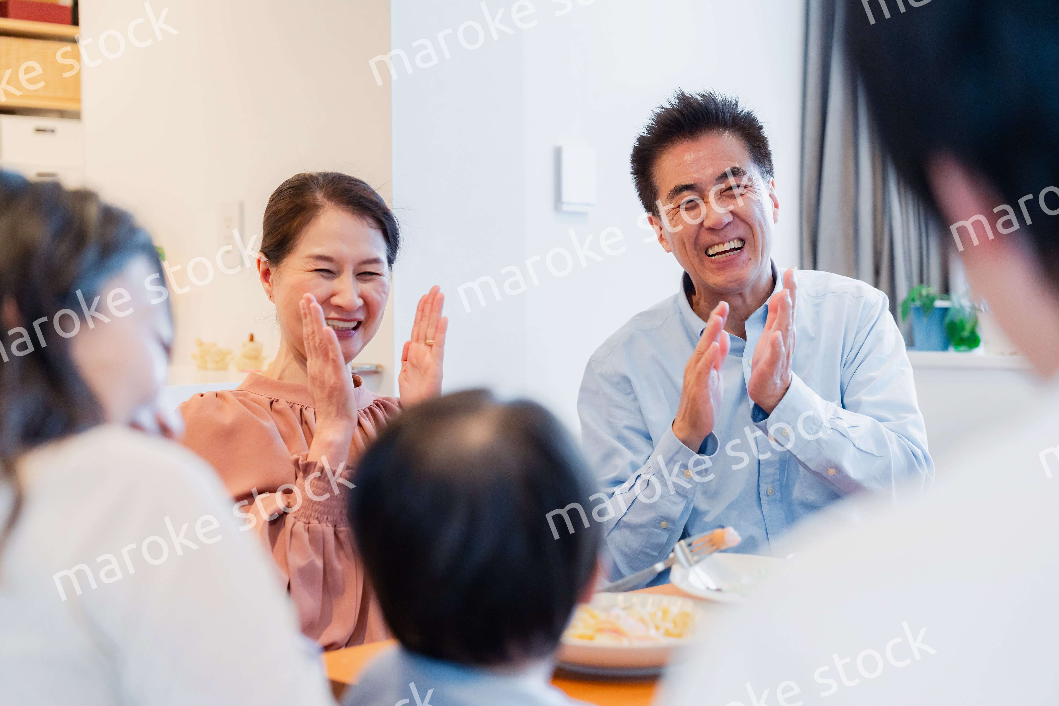 孫たちと一緒に楽しくごはんを食べる高齢の夫婦