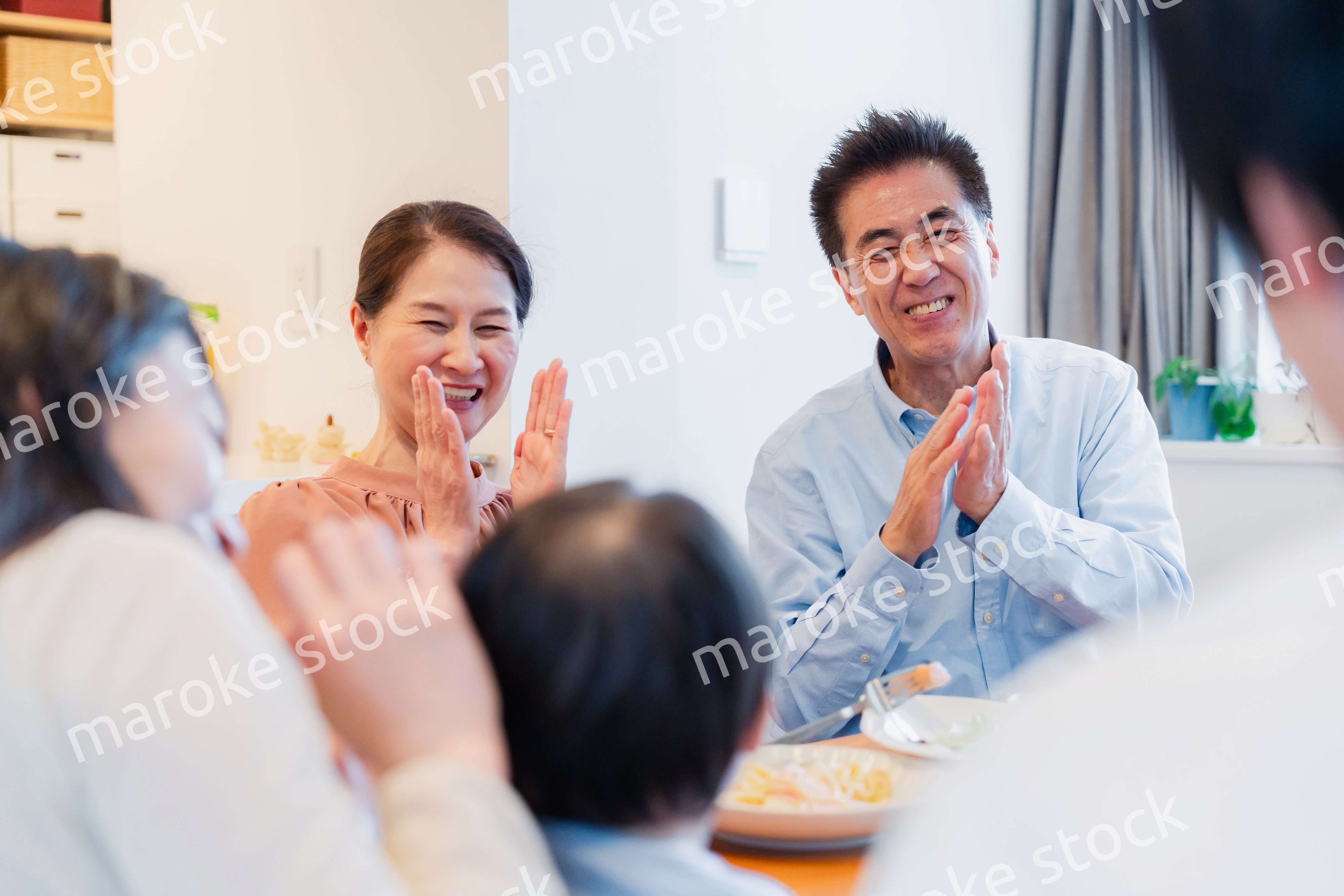 孫たちと一緒に楽しくごはんを食べる高齢の夫婦