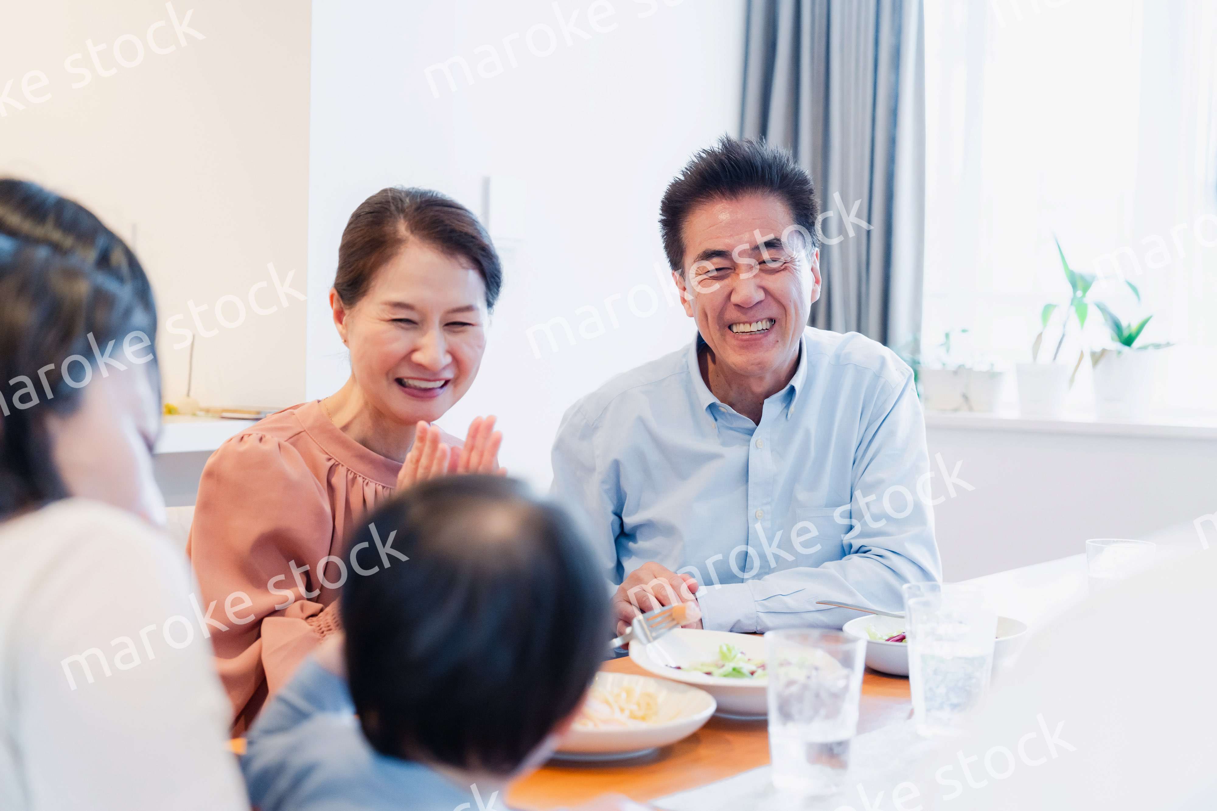 孫たちと一緒に楽しくごはんを食べる高齢の夫婦