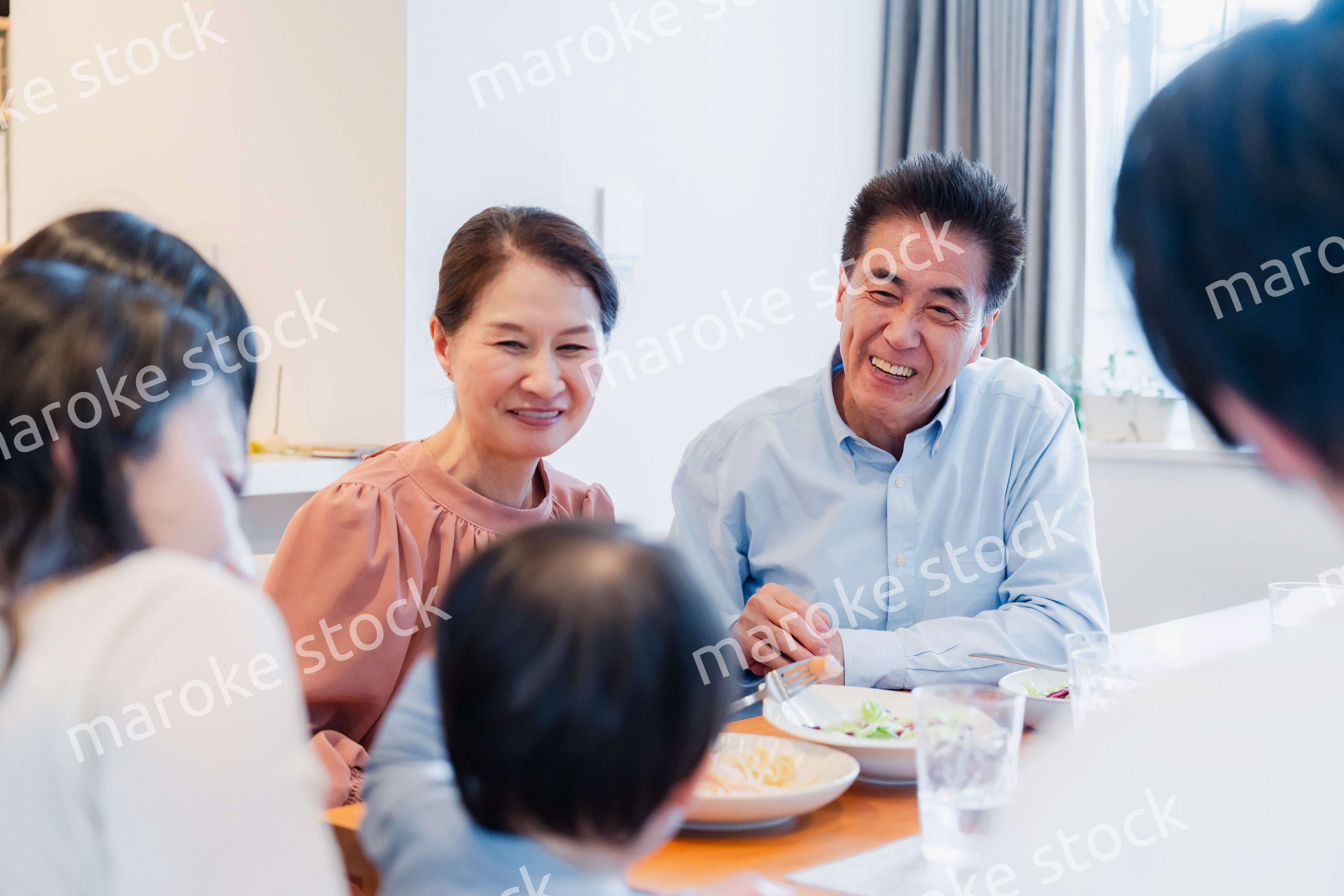 孫たちと一緒に楽しくごはんを食べる高齢の夫婦