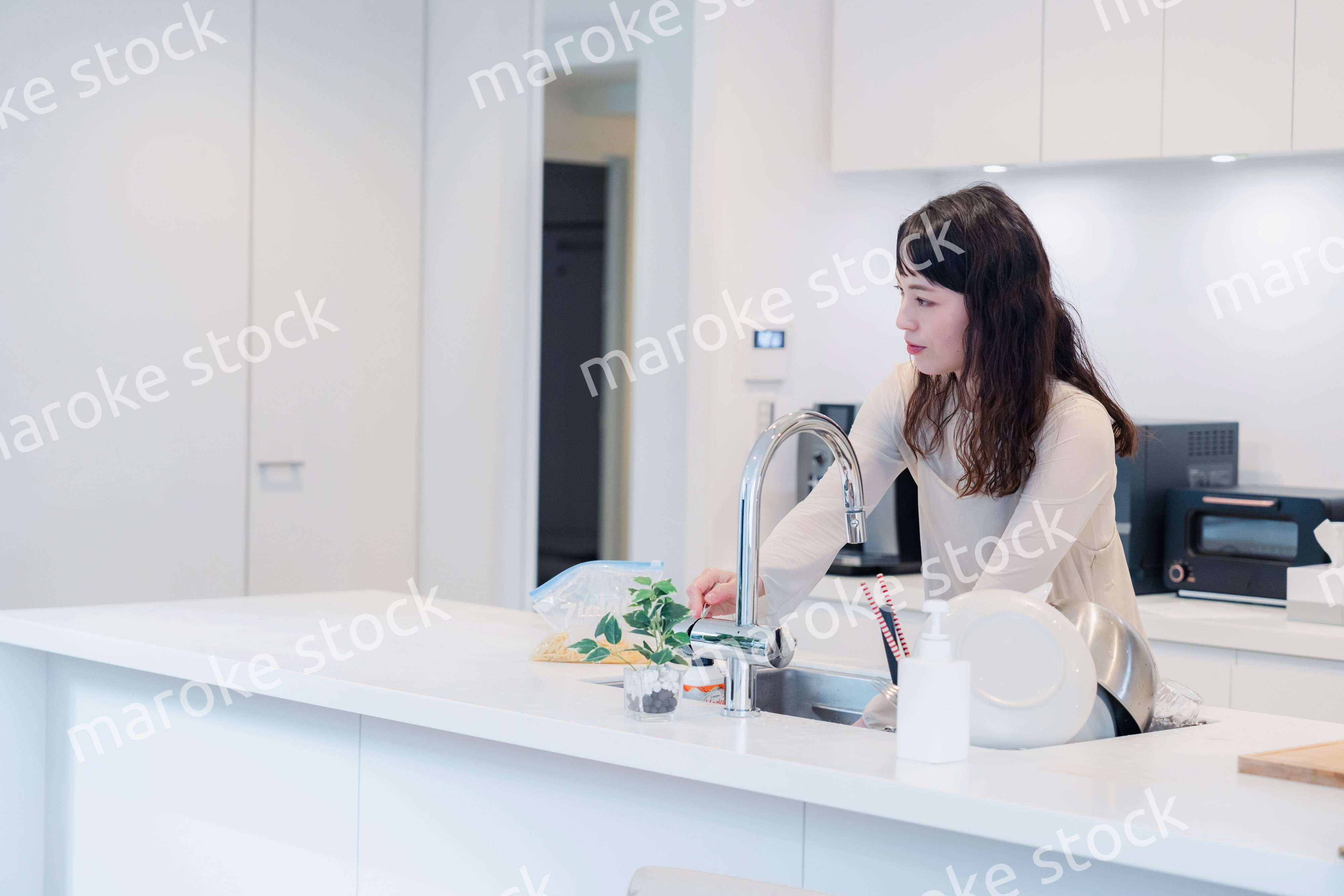 キッチンで忙しく家事をする主婦