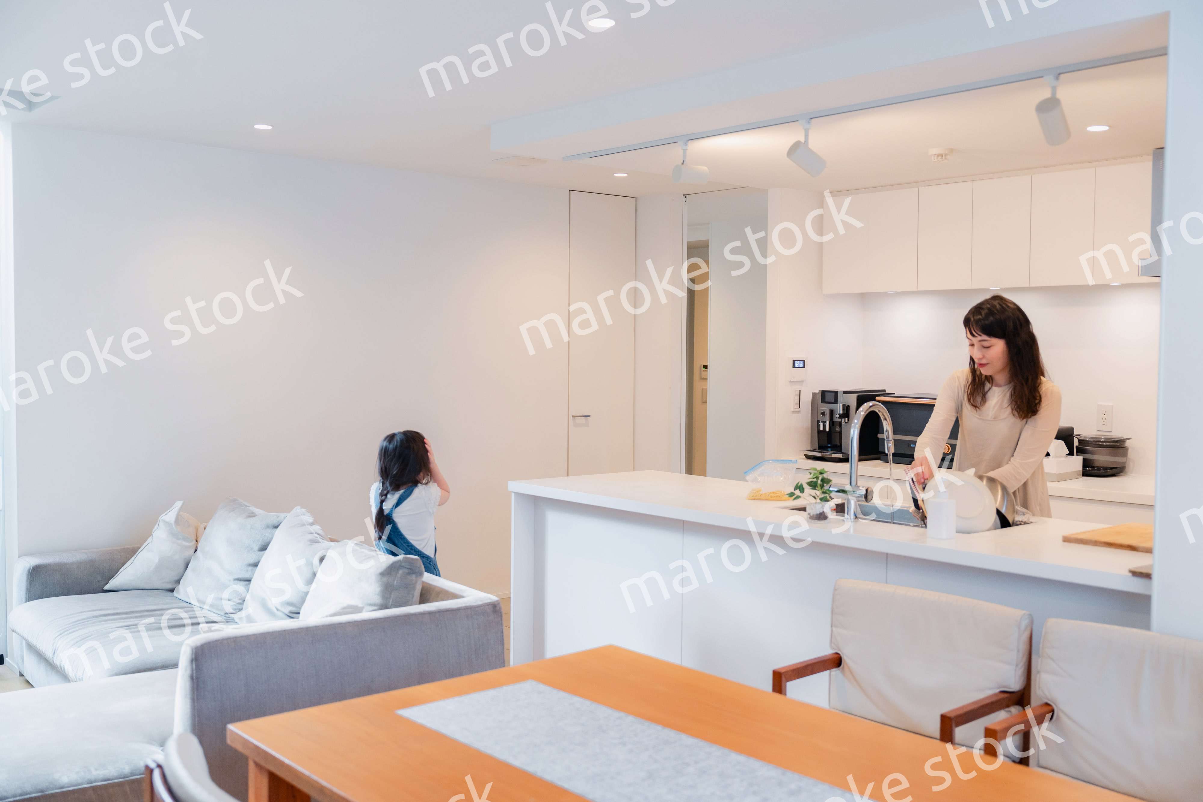 キッチンで家事をしながら子供と会話をするお母さん