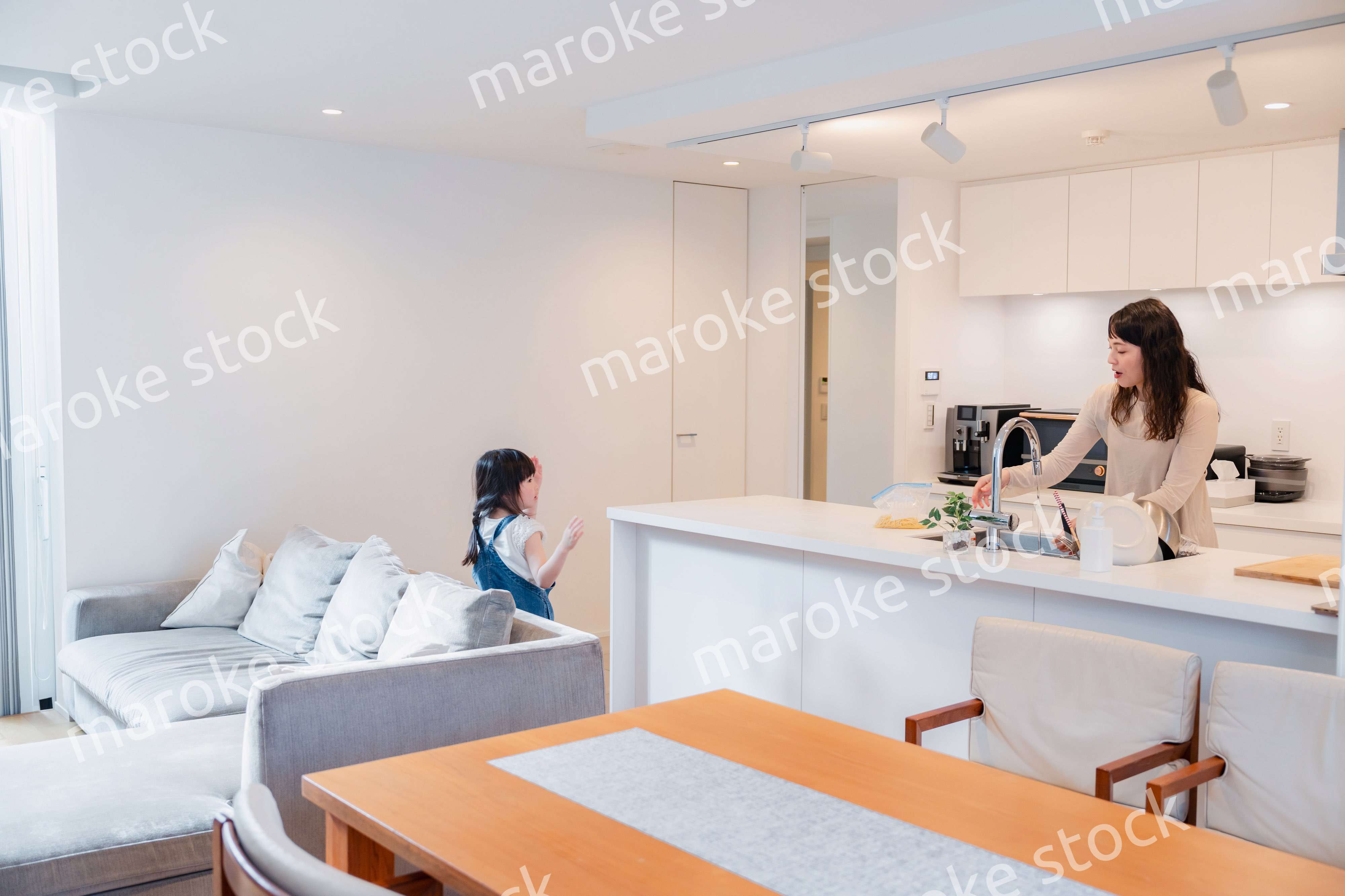 キッチンで家事をしながら子供と会話をするお母さん