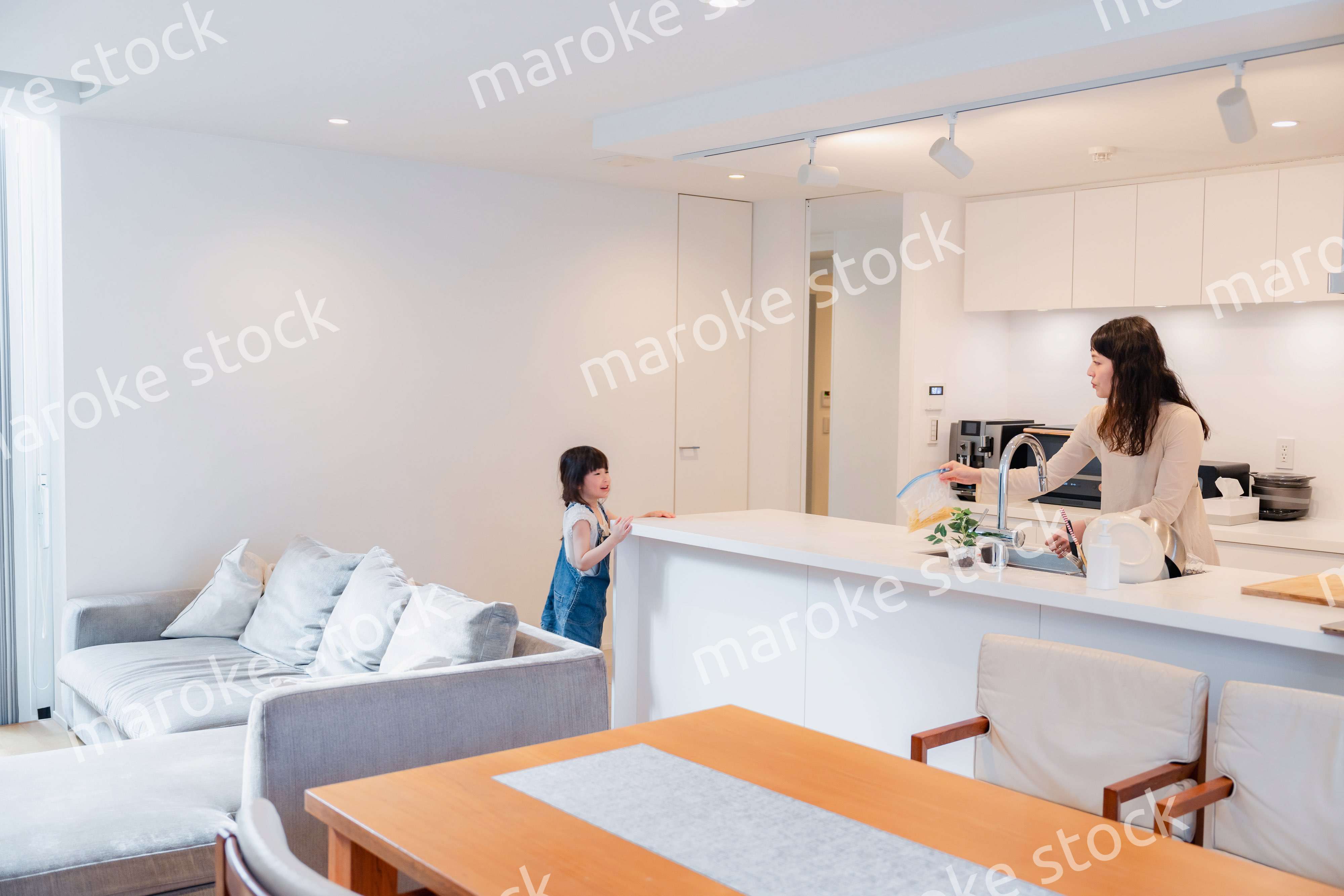 キッチンで家事をしながら子供と会話をするお母さん