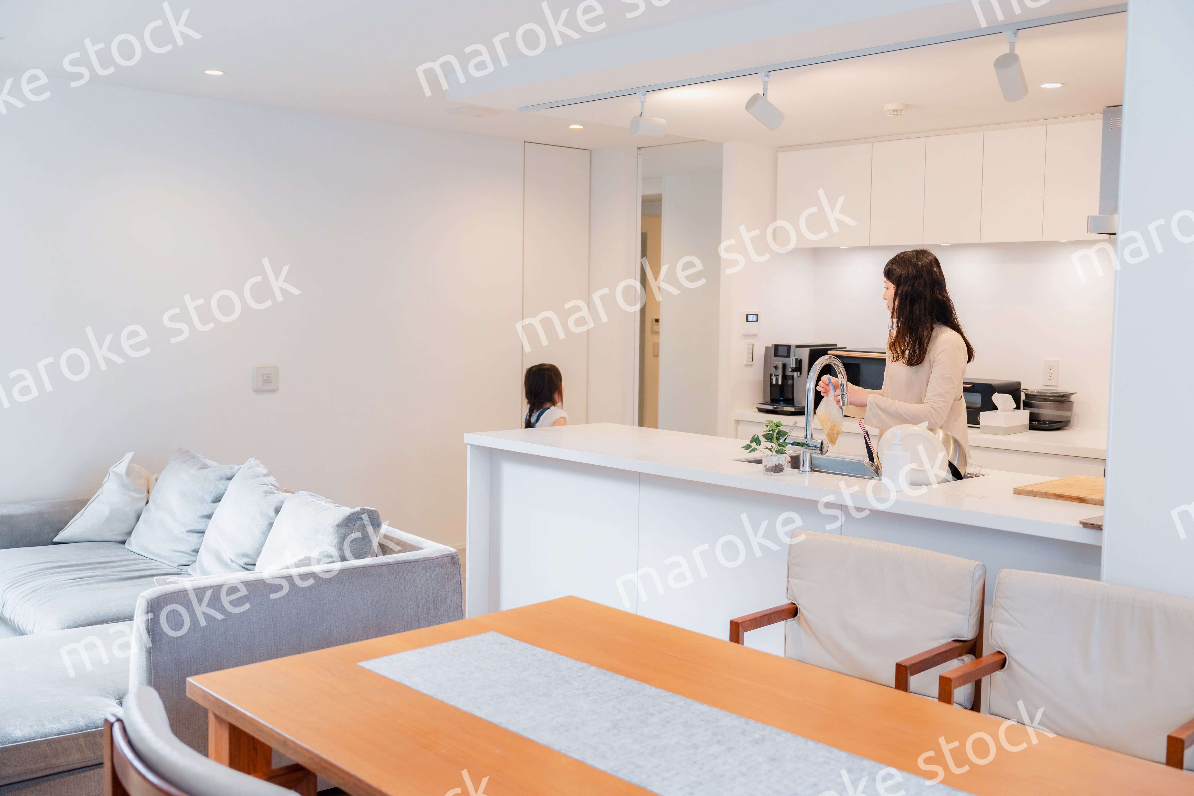 キッチンで家事をしながら子供と会話をするお母さん