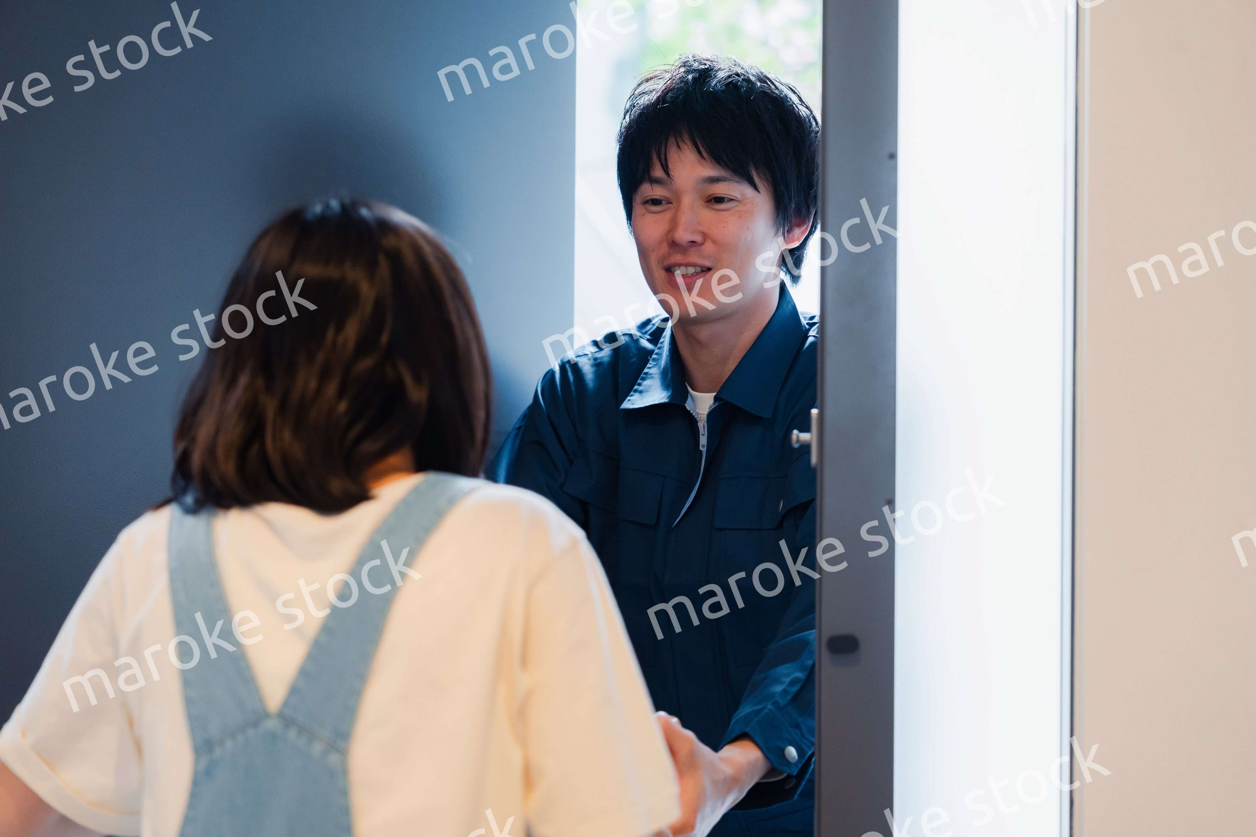 笑顔で宅配便の配達をする若い男性