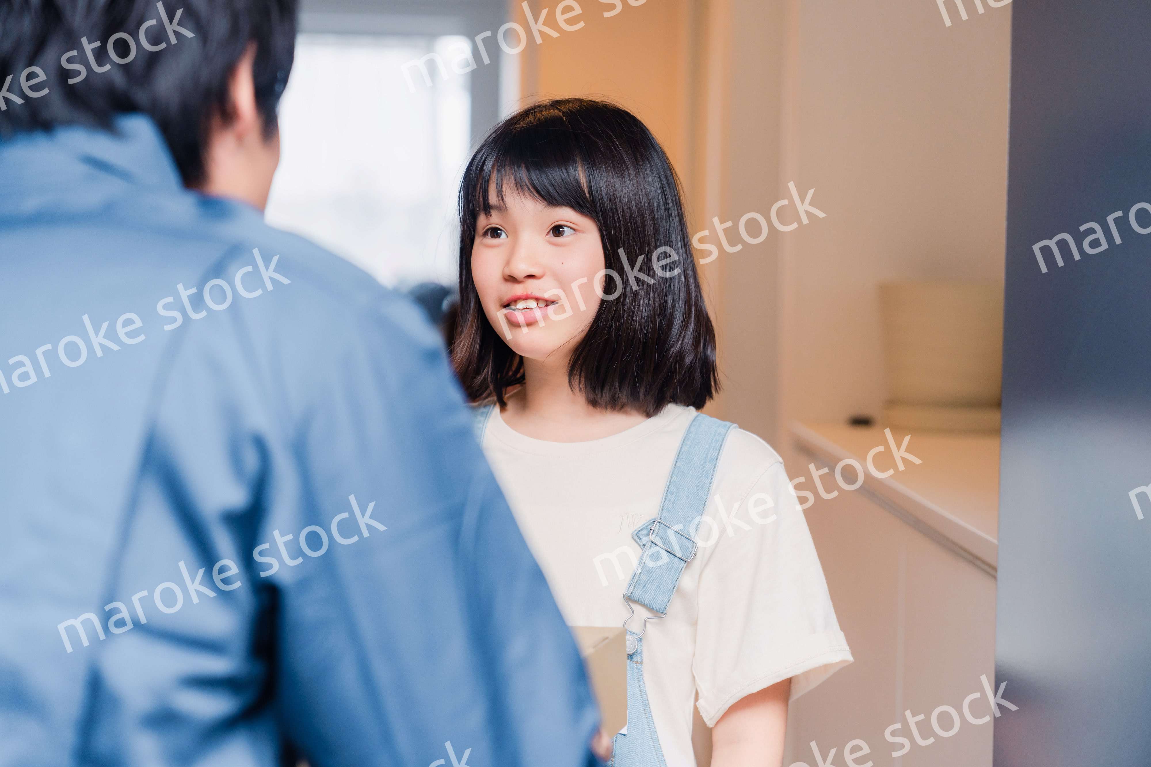 家で宅配便を受け取る小学生の女の子