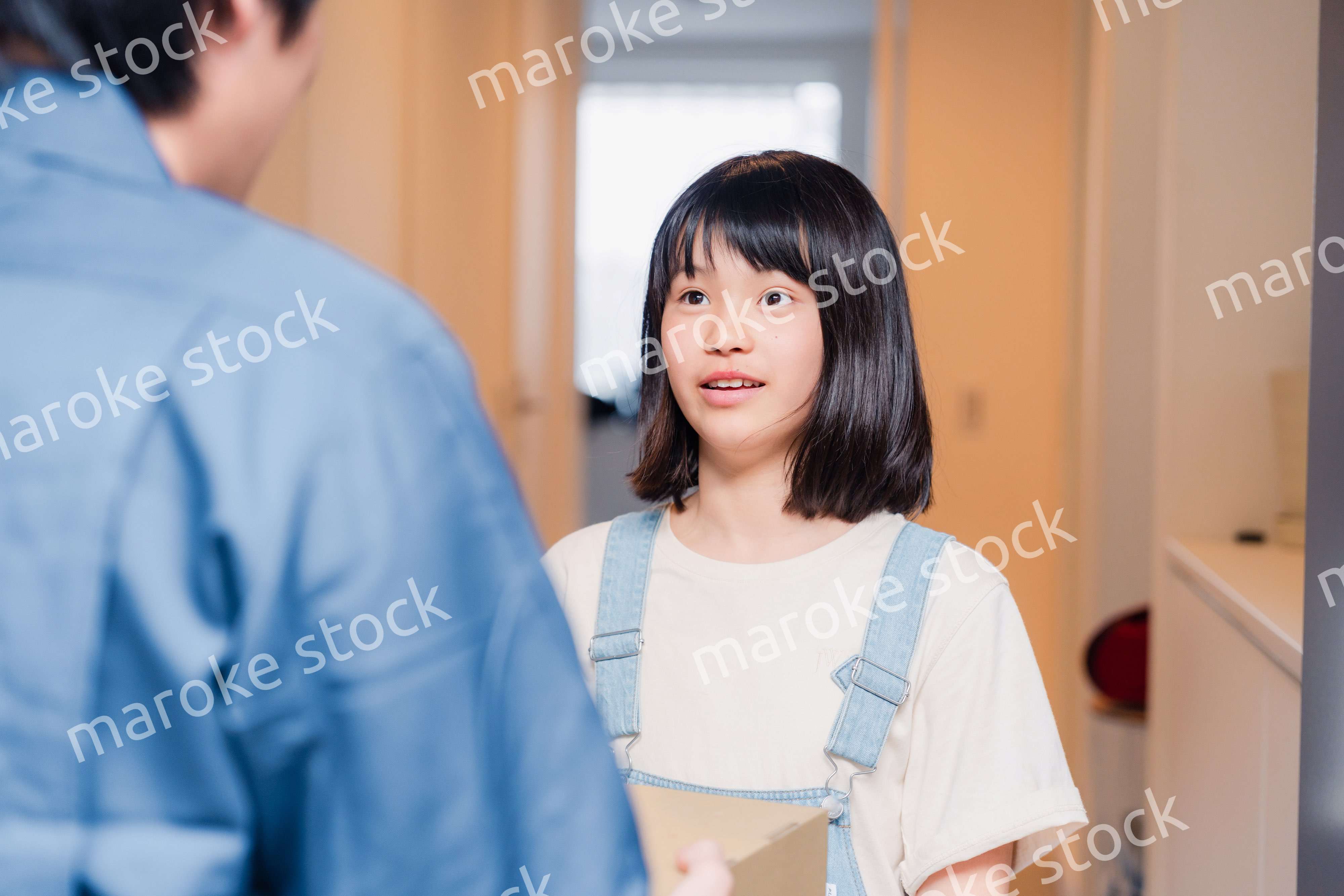 家で宅配便を受け取る小学生の女の子