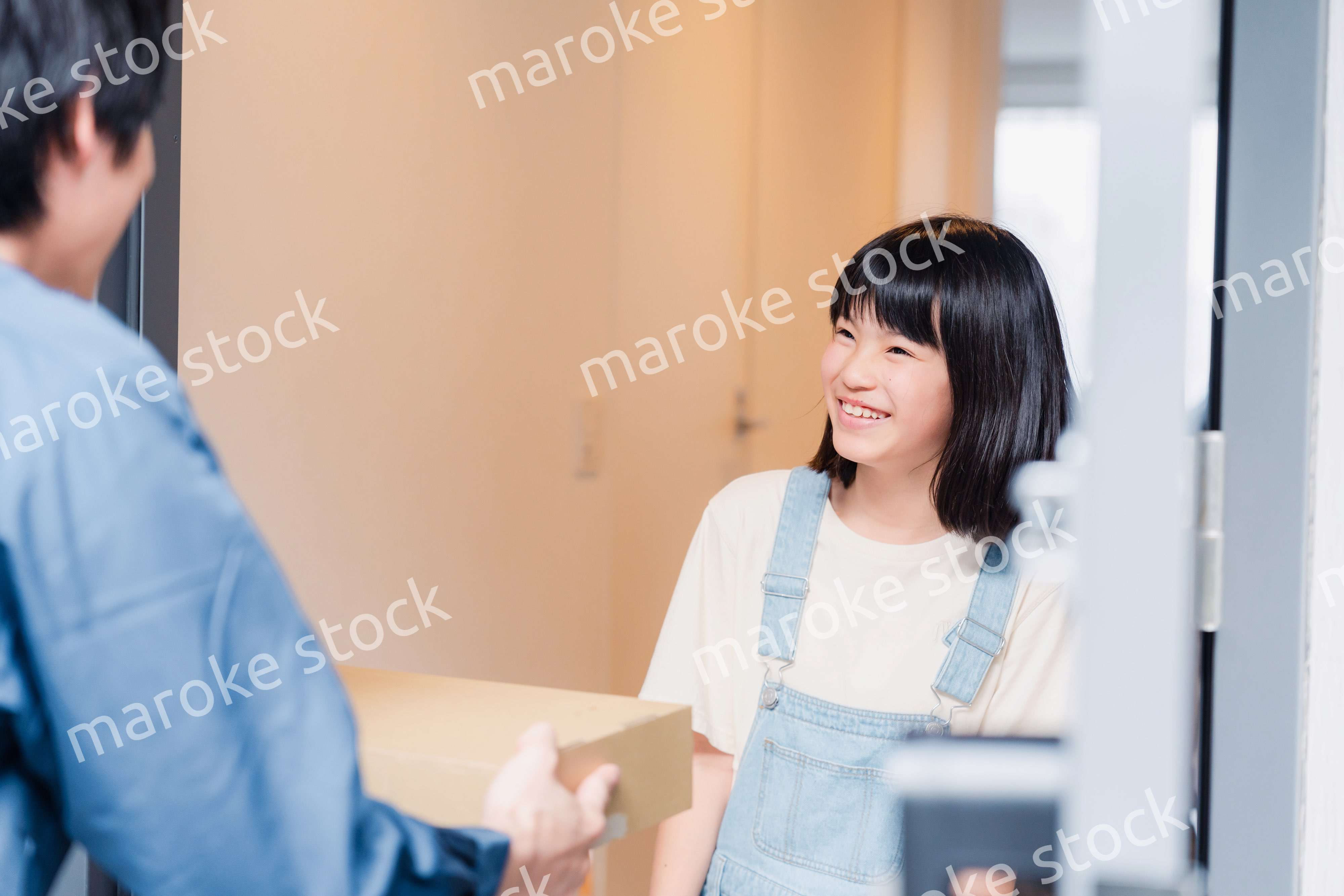 家で宅配便を受け取る小学生の女の子