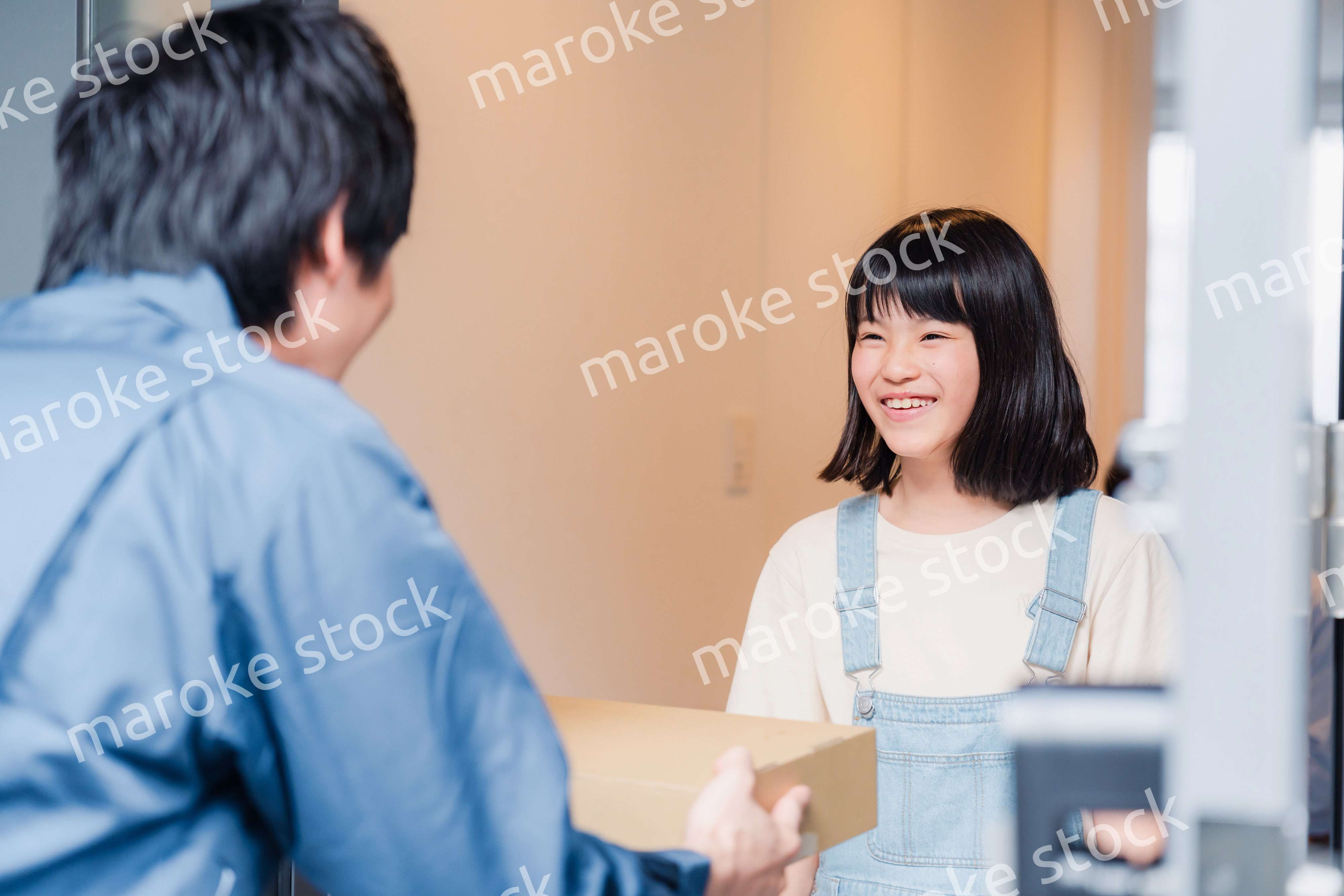 家で宅配便を受け取る小学生の女の子