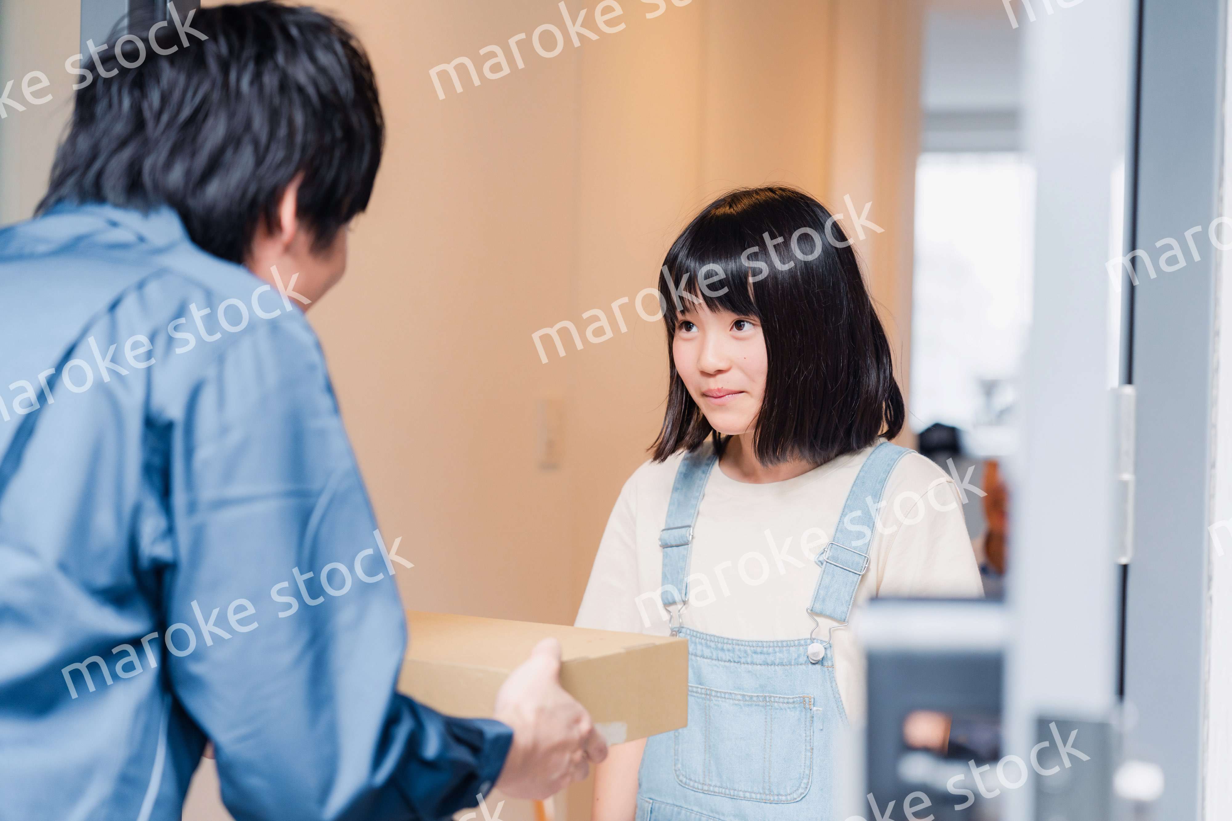 家で宅配便を受け取る小学生の女の子