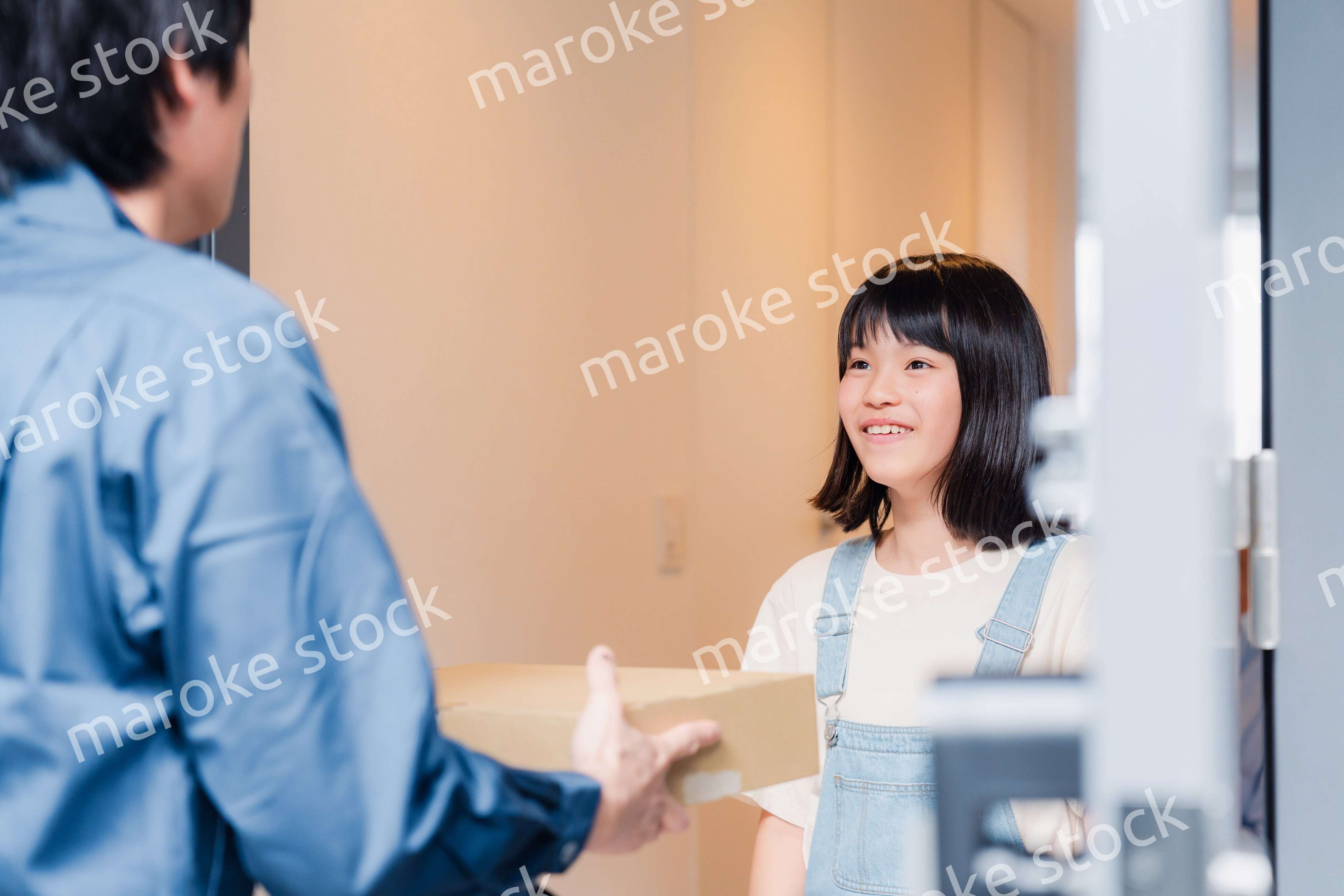 家で宅配便を受け取る小学生の女の子