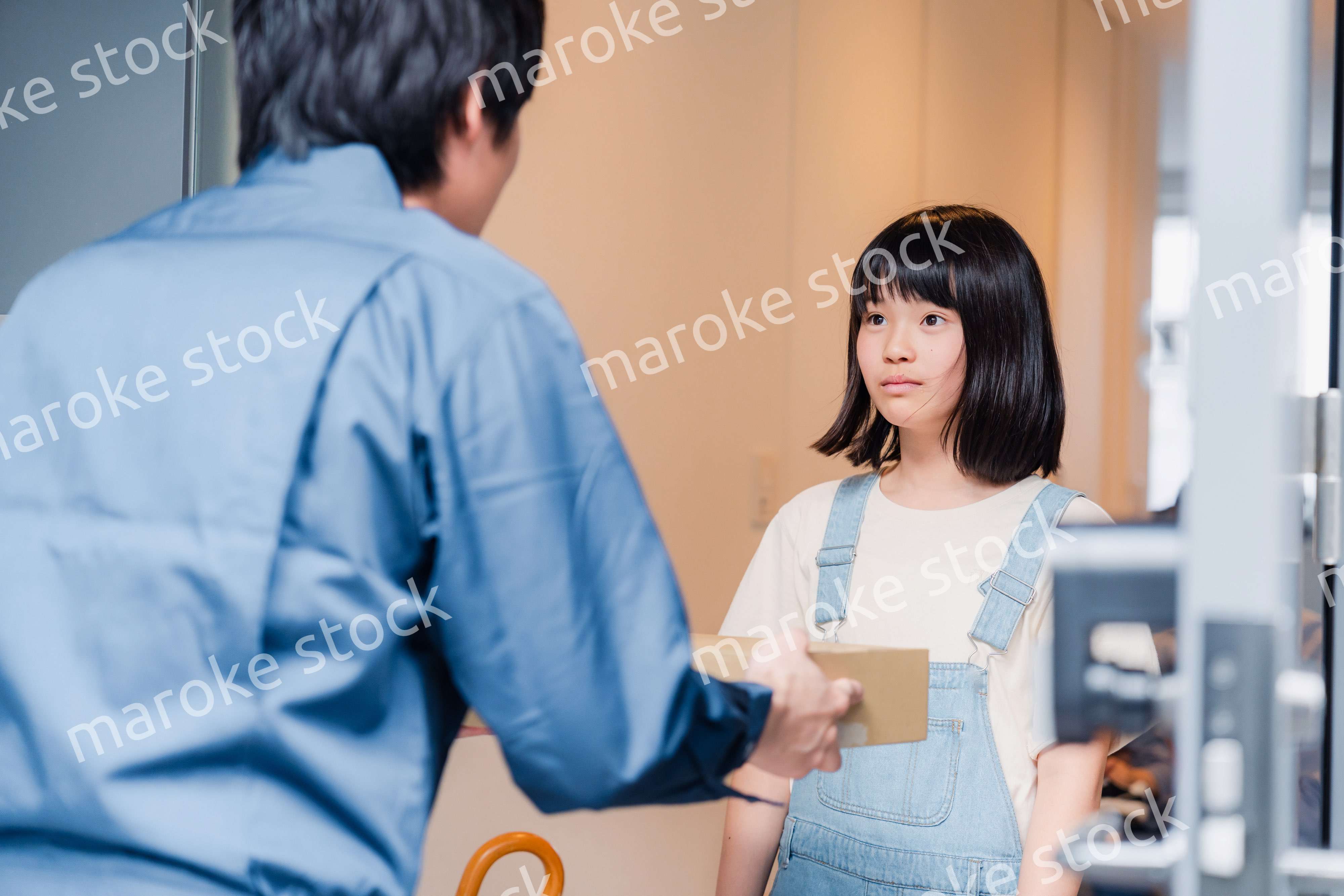 家で宅配便を受け取る小学生の女の子