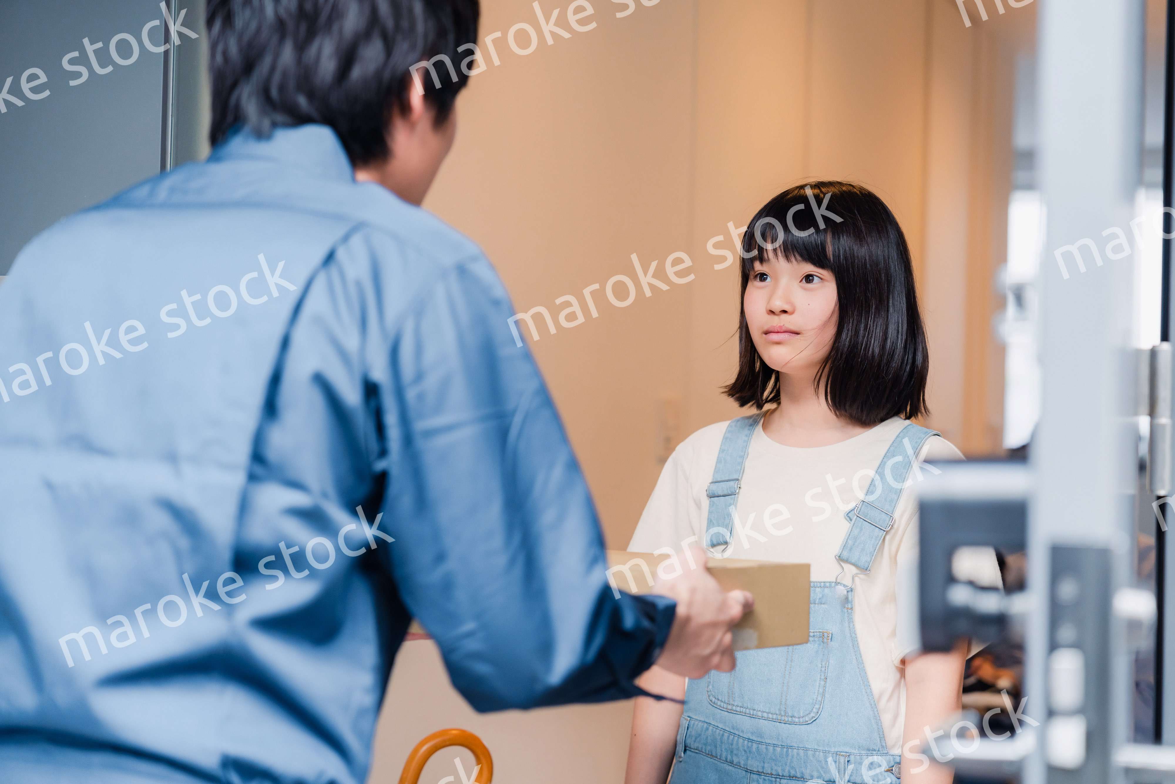 家で宅配便を受け取る小学生の女の子