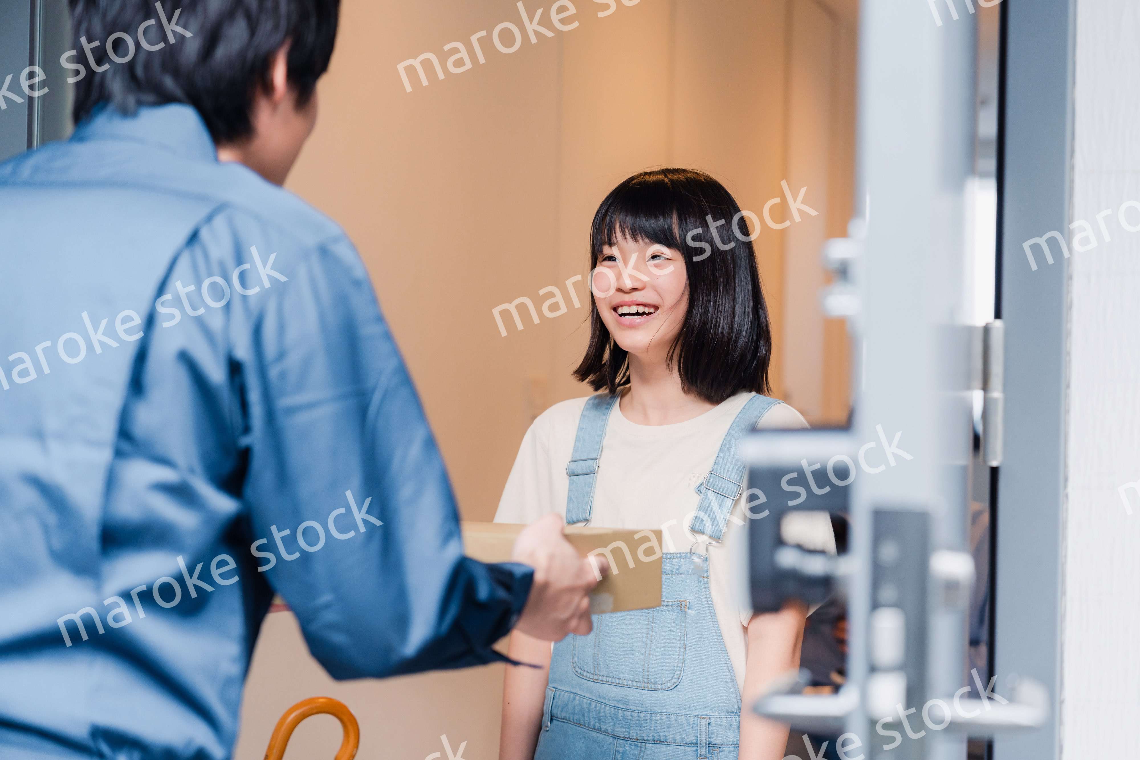 家で宅配便を受け取る小学生の女の子