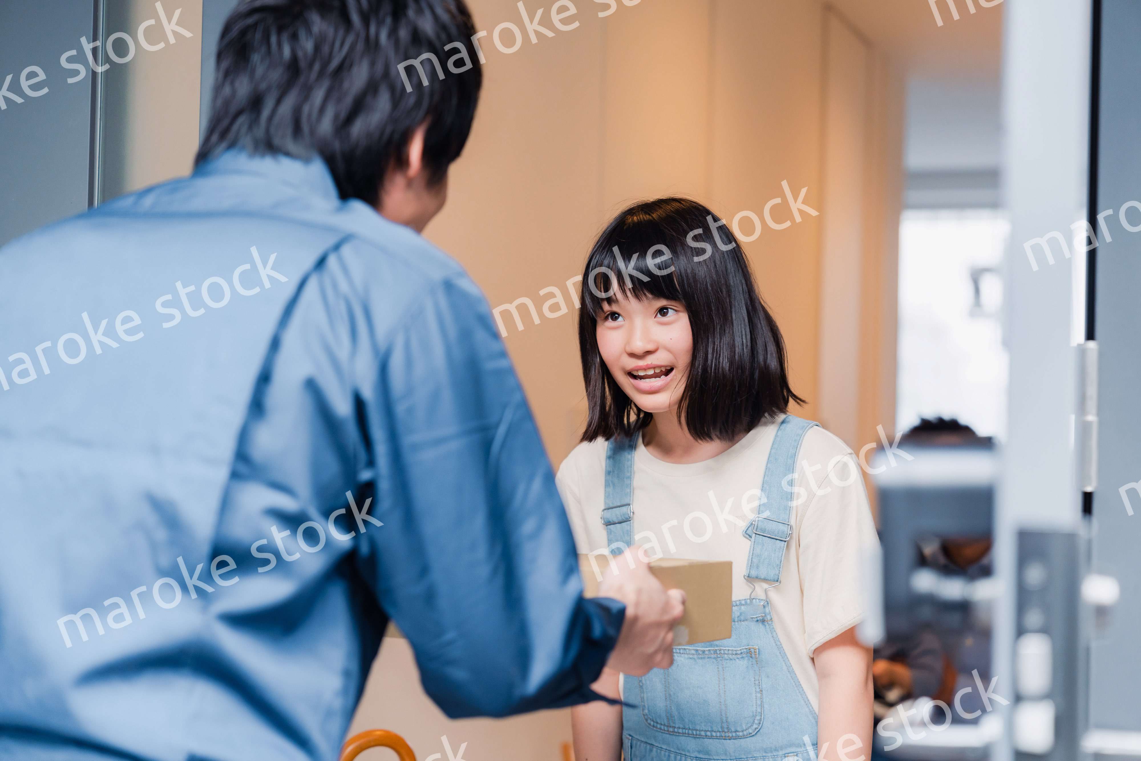 家で宅配便を受け取る小学生の女の子