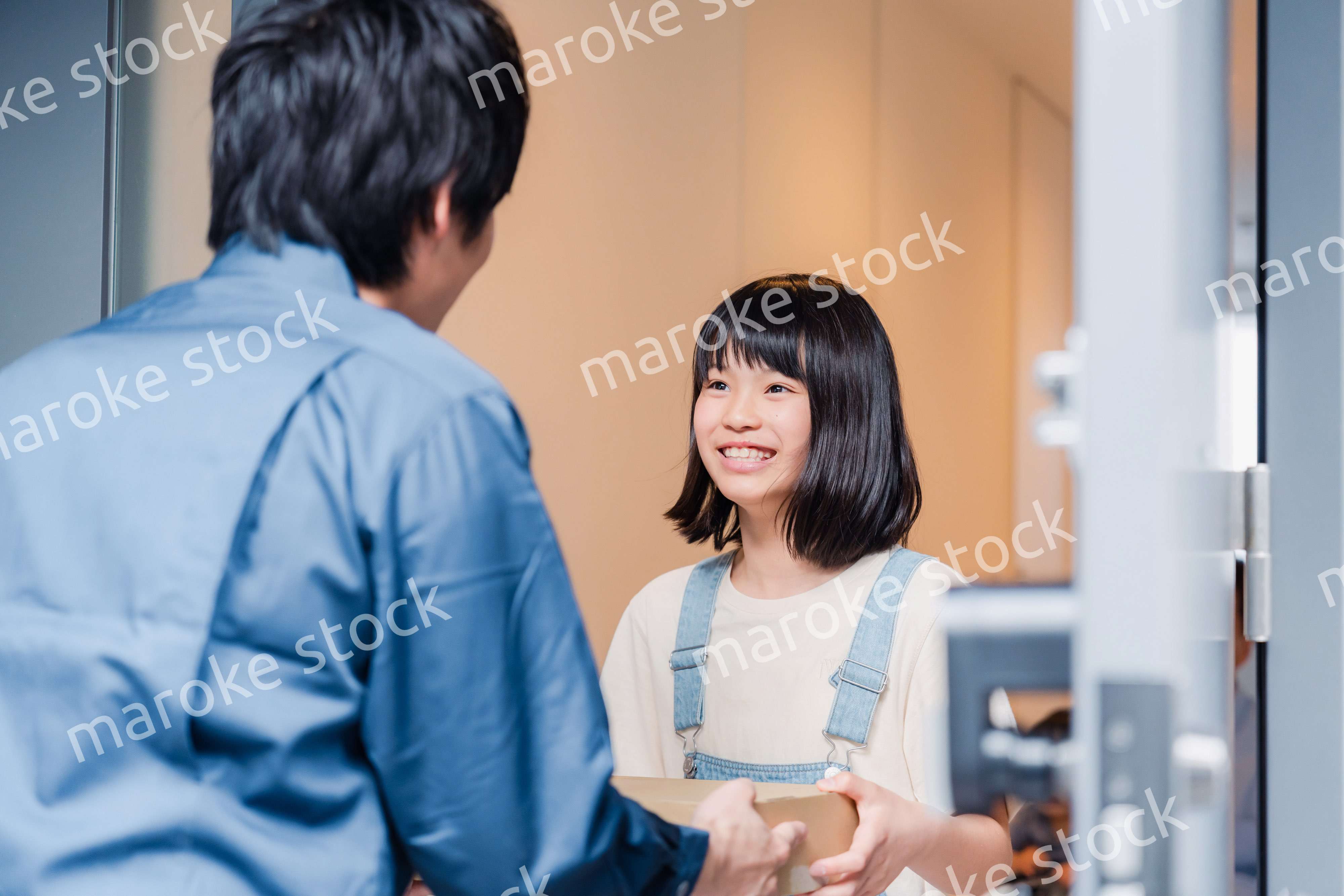 家で宅配便を受け取る小学生の女の子