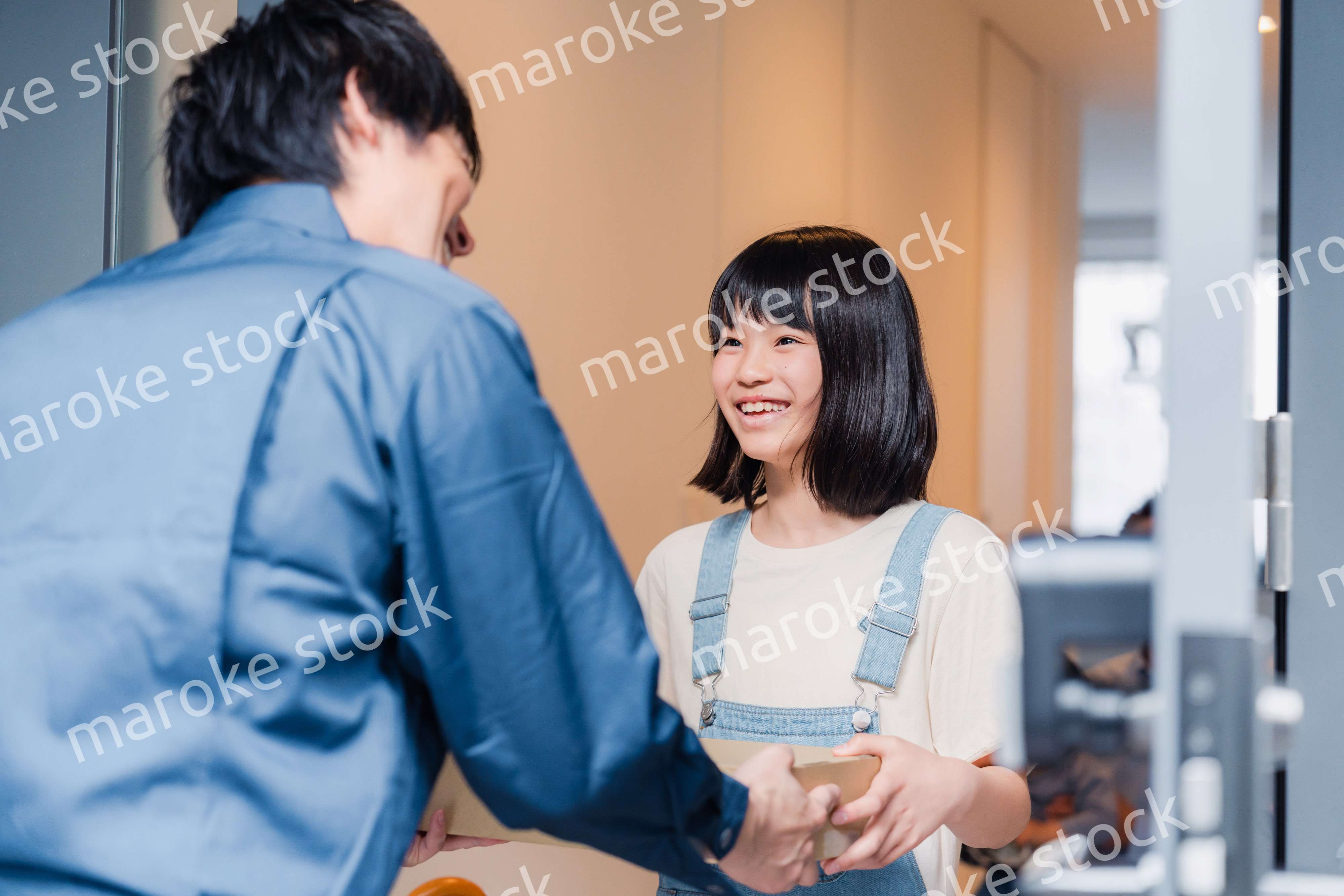 家で宅配便を受け取る小学生の女の子