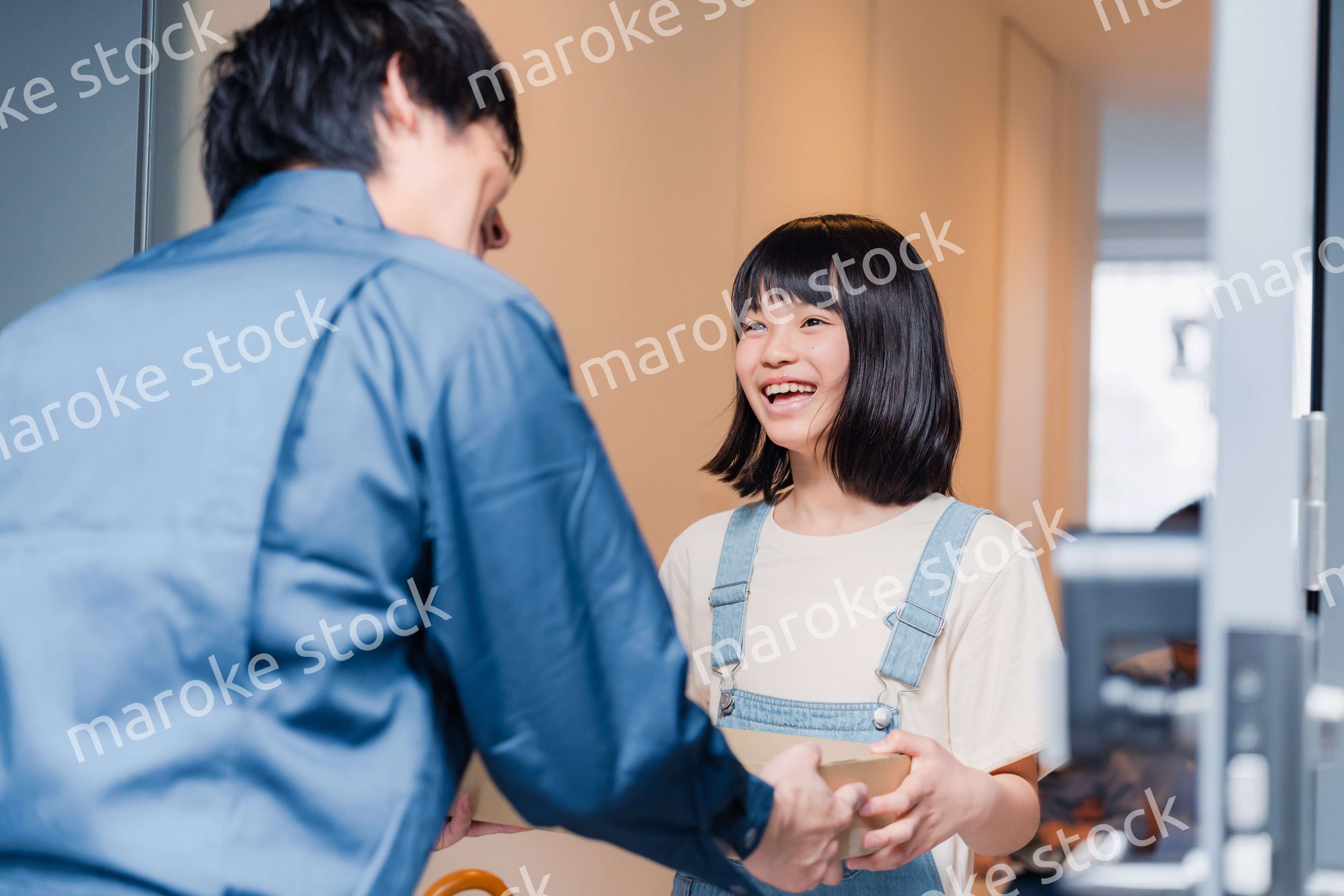 家で宅配便を受け取る小学生の女の子