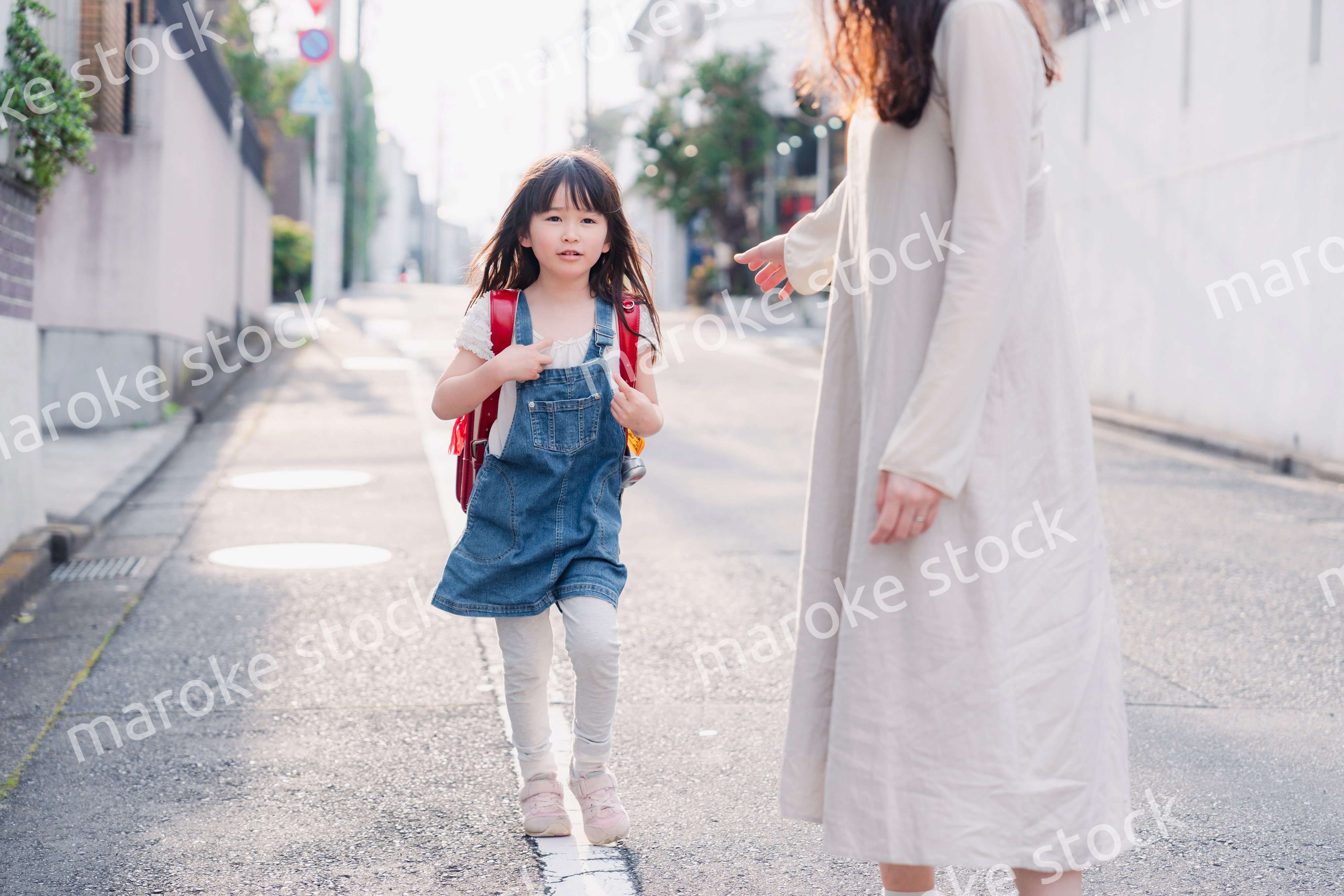 小学生の女の子のお迎えをするお母さん