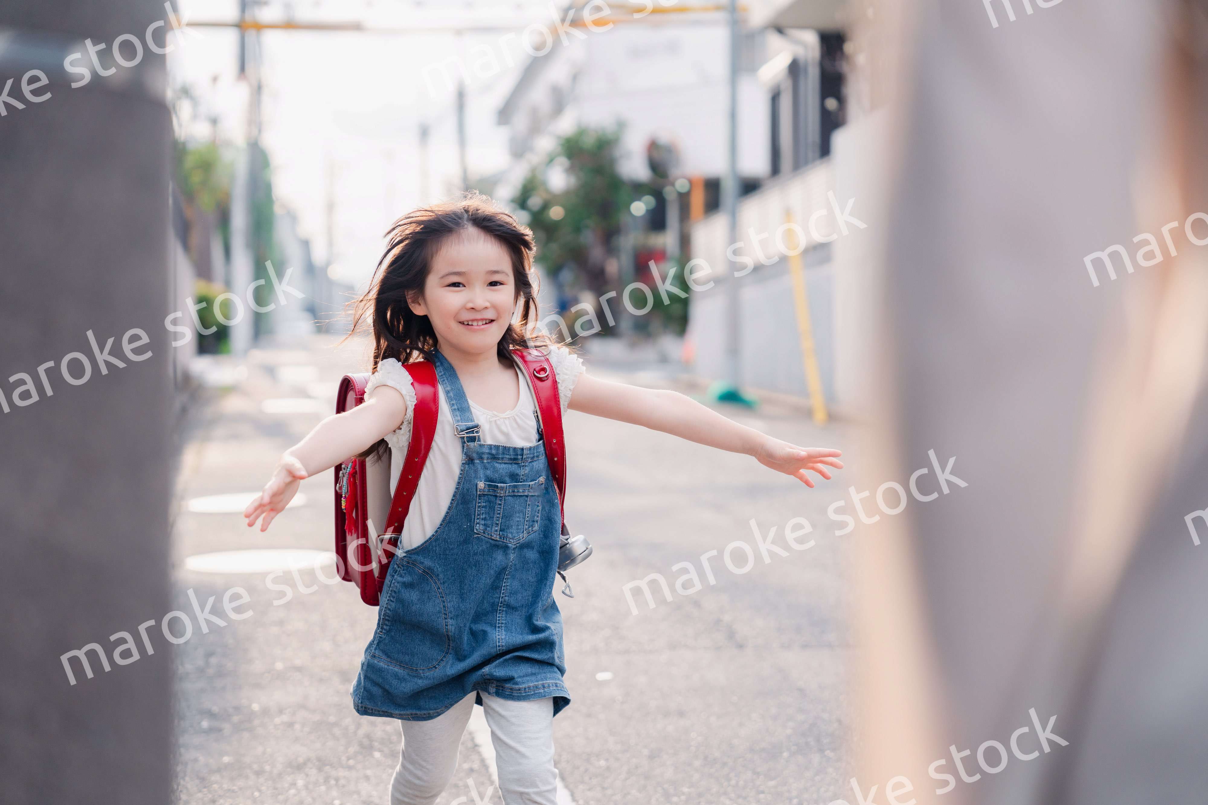 ランドセルを背負ってお母さんのところに走ってくる小学生の女の子