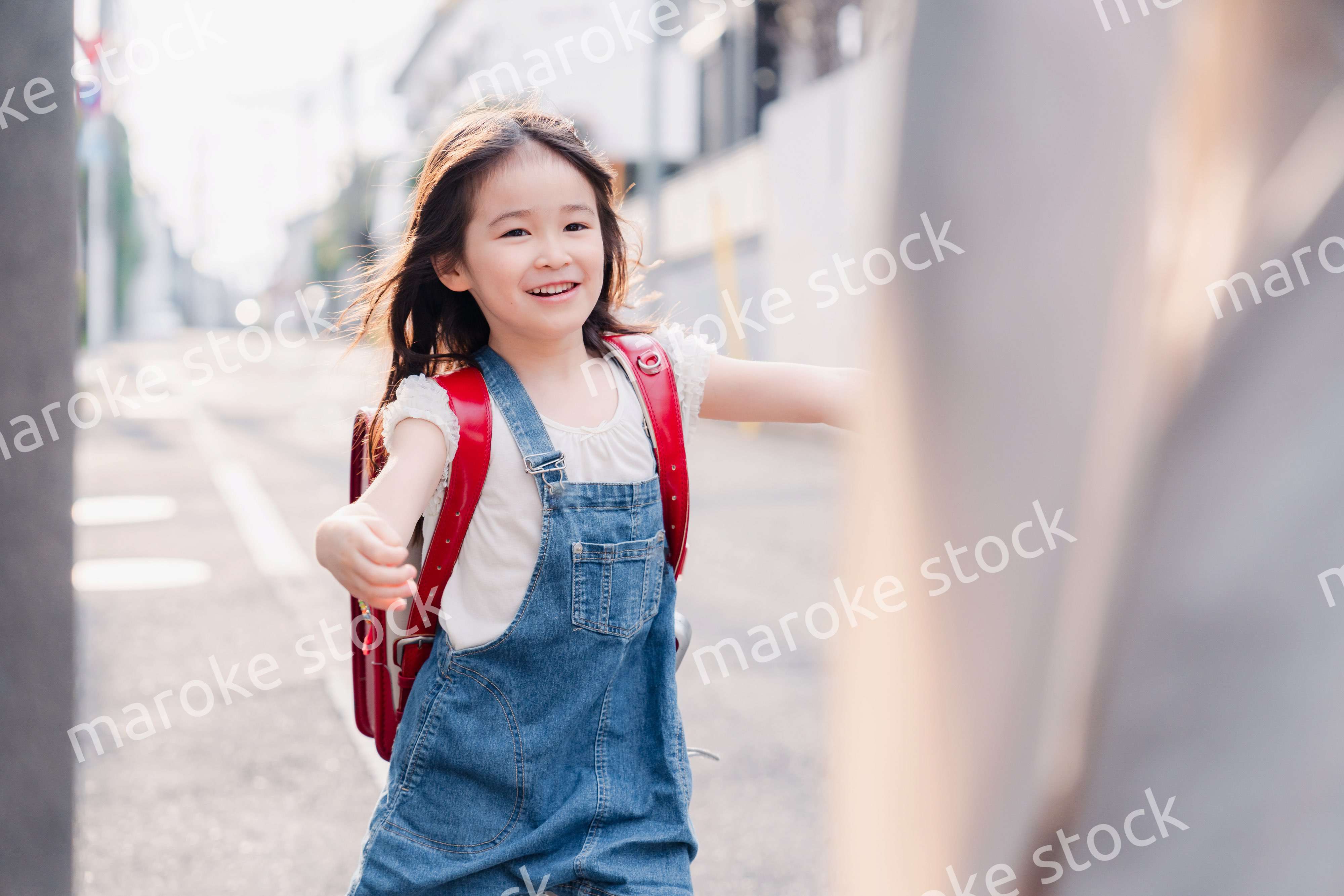 ランドセルを背負ってお母さんのところに走ってくる小学生の女の子