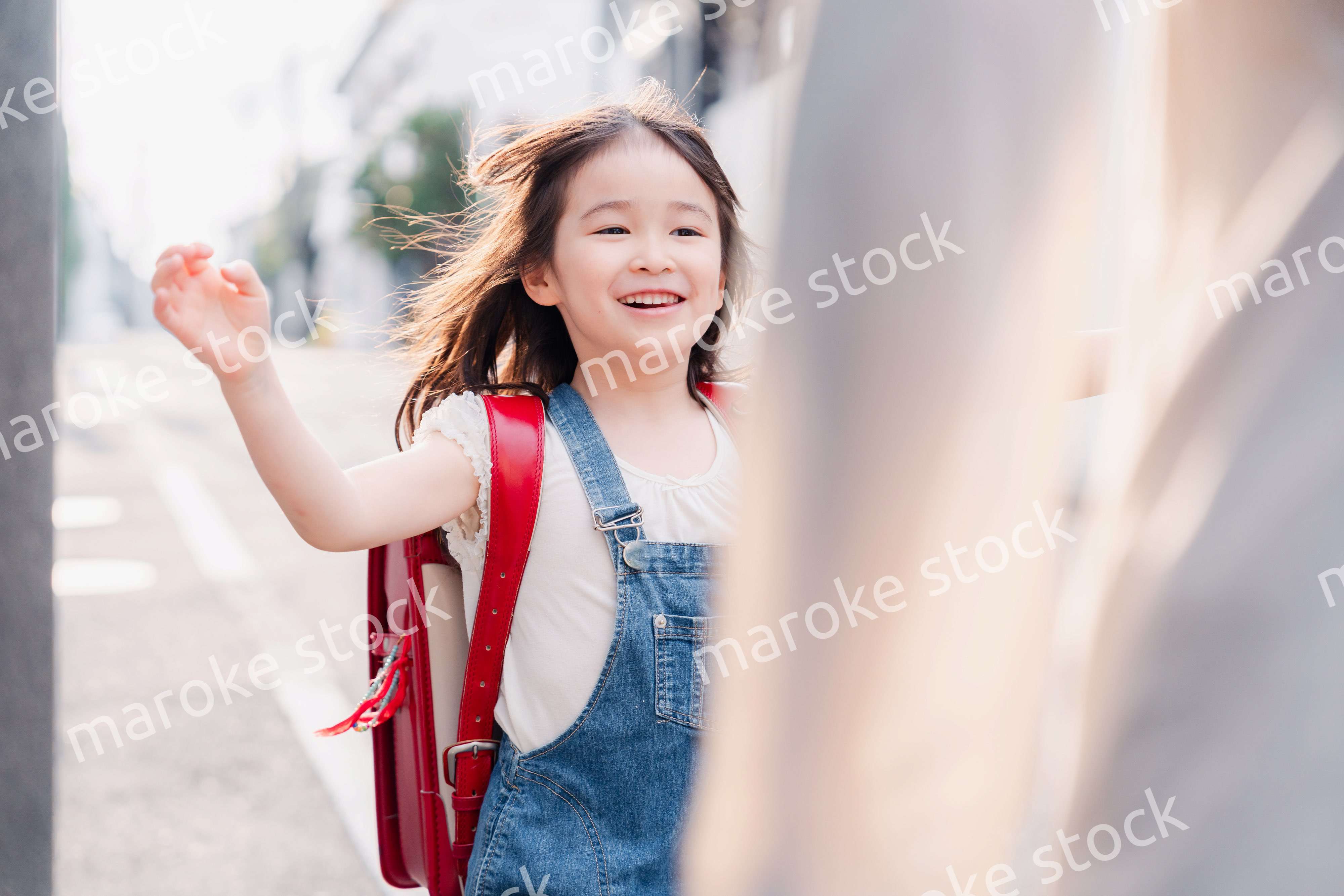 ランドセルを背負ってお母さんのところに走ってくる小学生の女の子