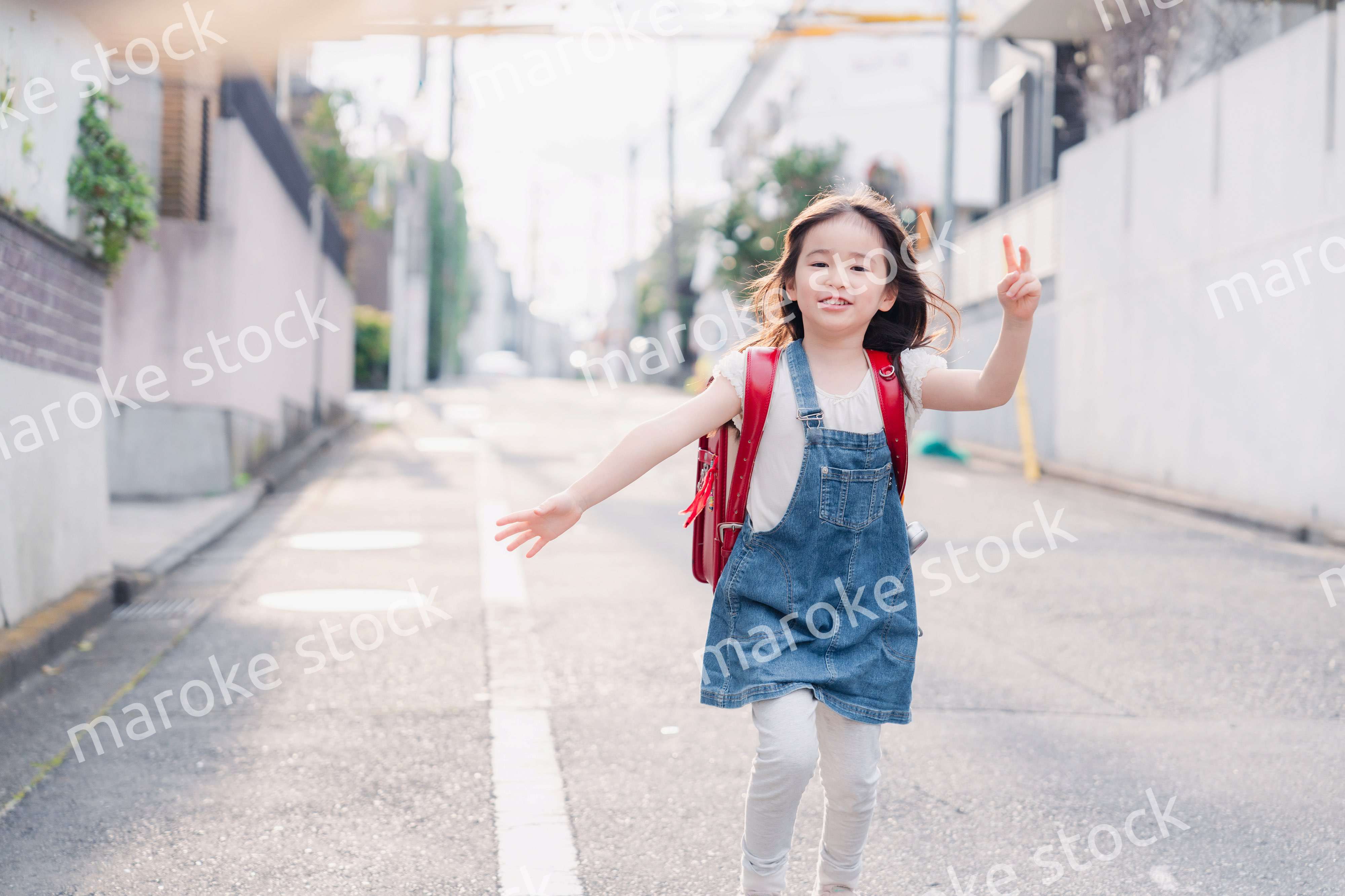 ランドセルを背負ってお母さんのところに走ってくる小学生の女の子