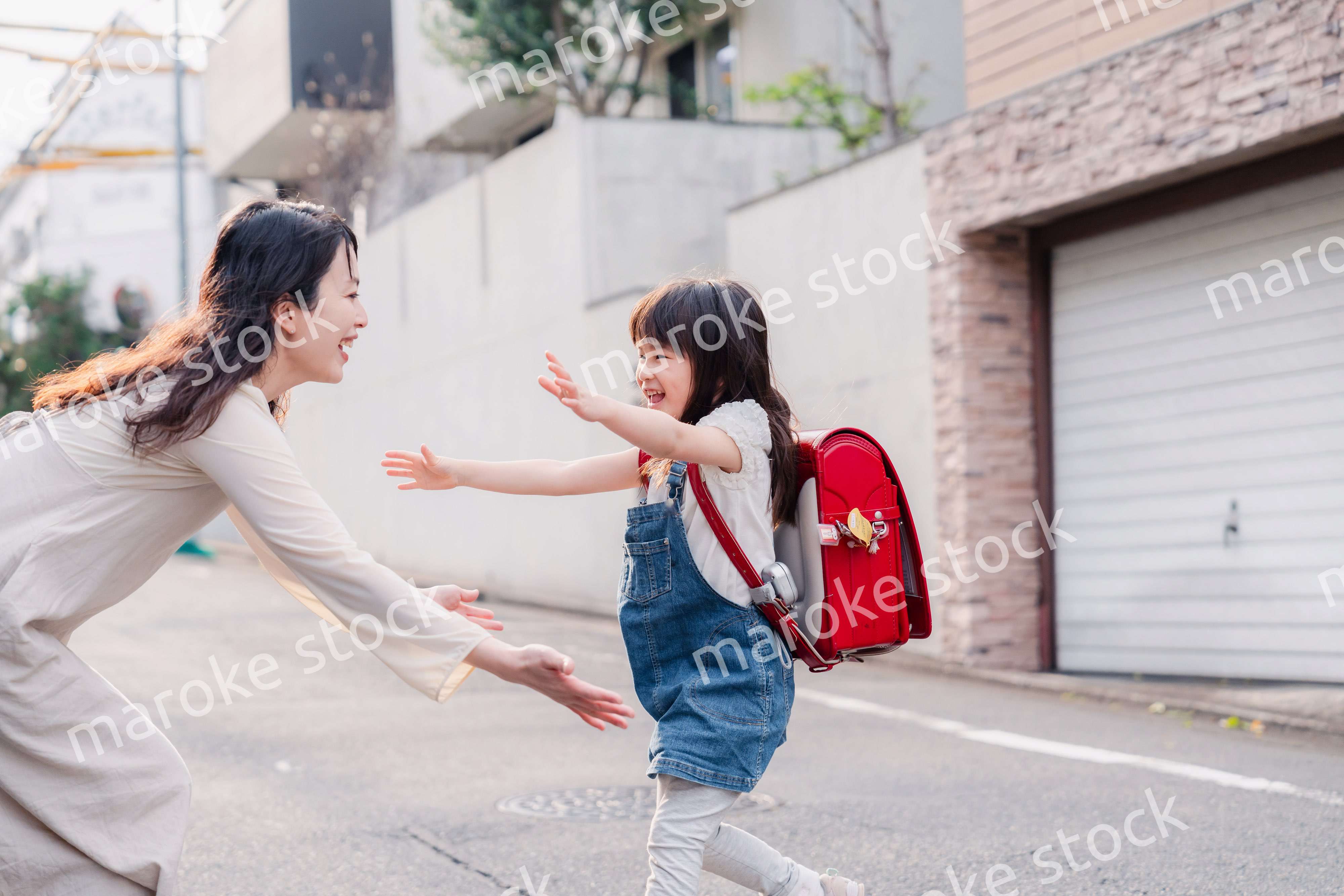 小学生の女の子のお迎えをするお母さん