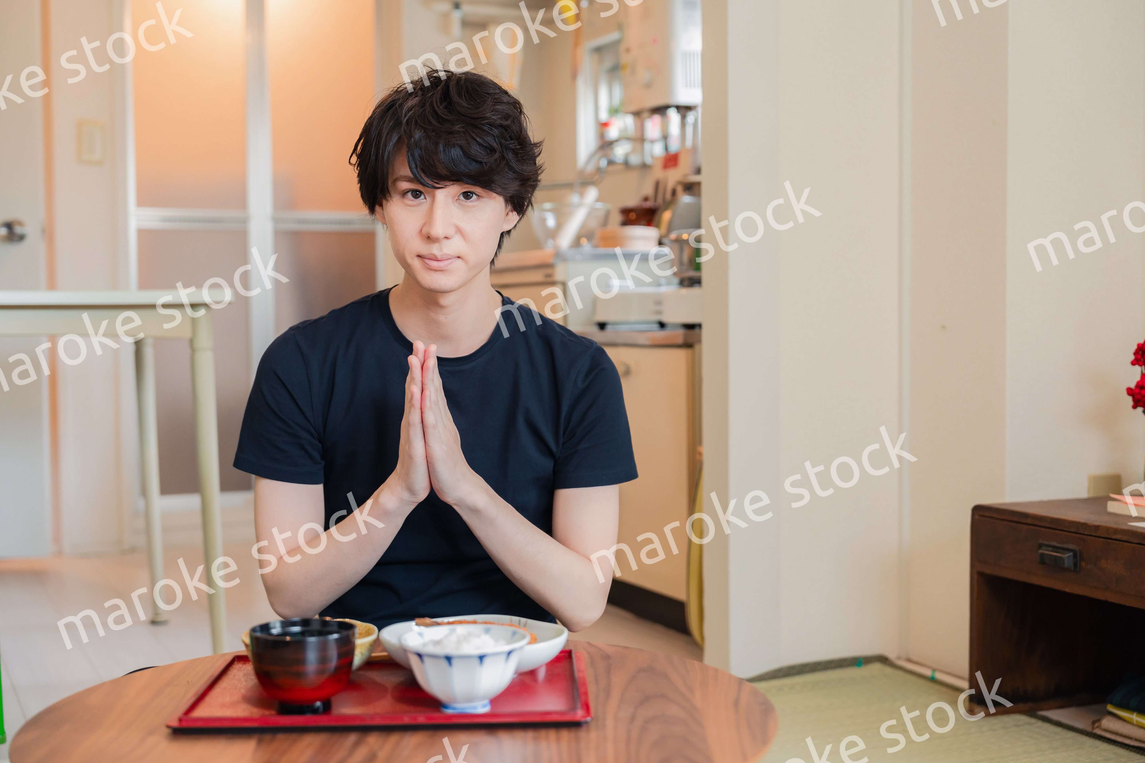 一人暮らしの下宿先でごはんを食べる若い男性