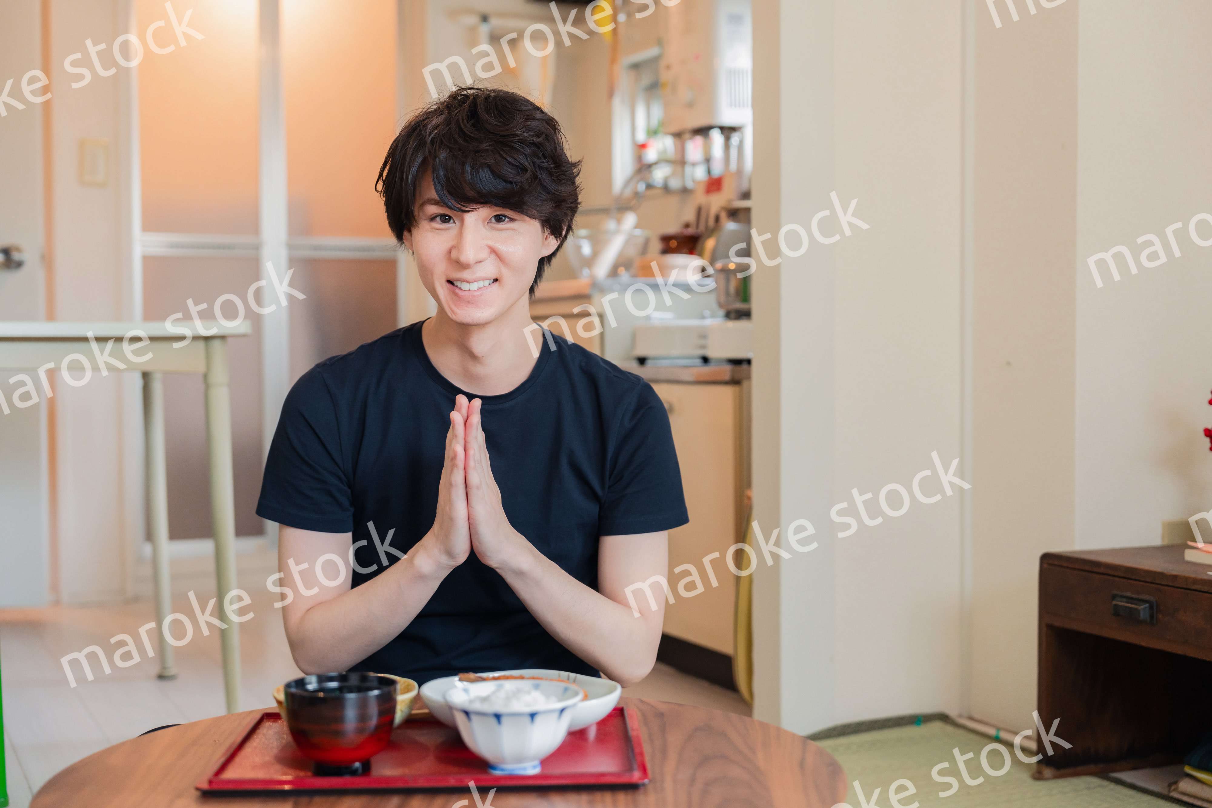 一人暮らしの下宿先でごはんを食べる若い男性