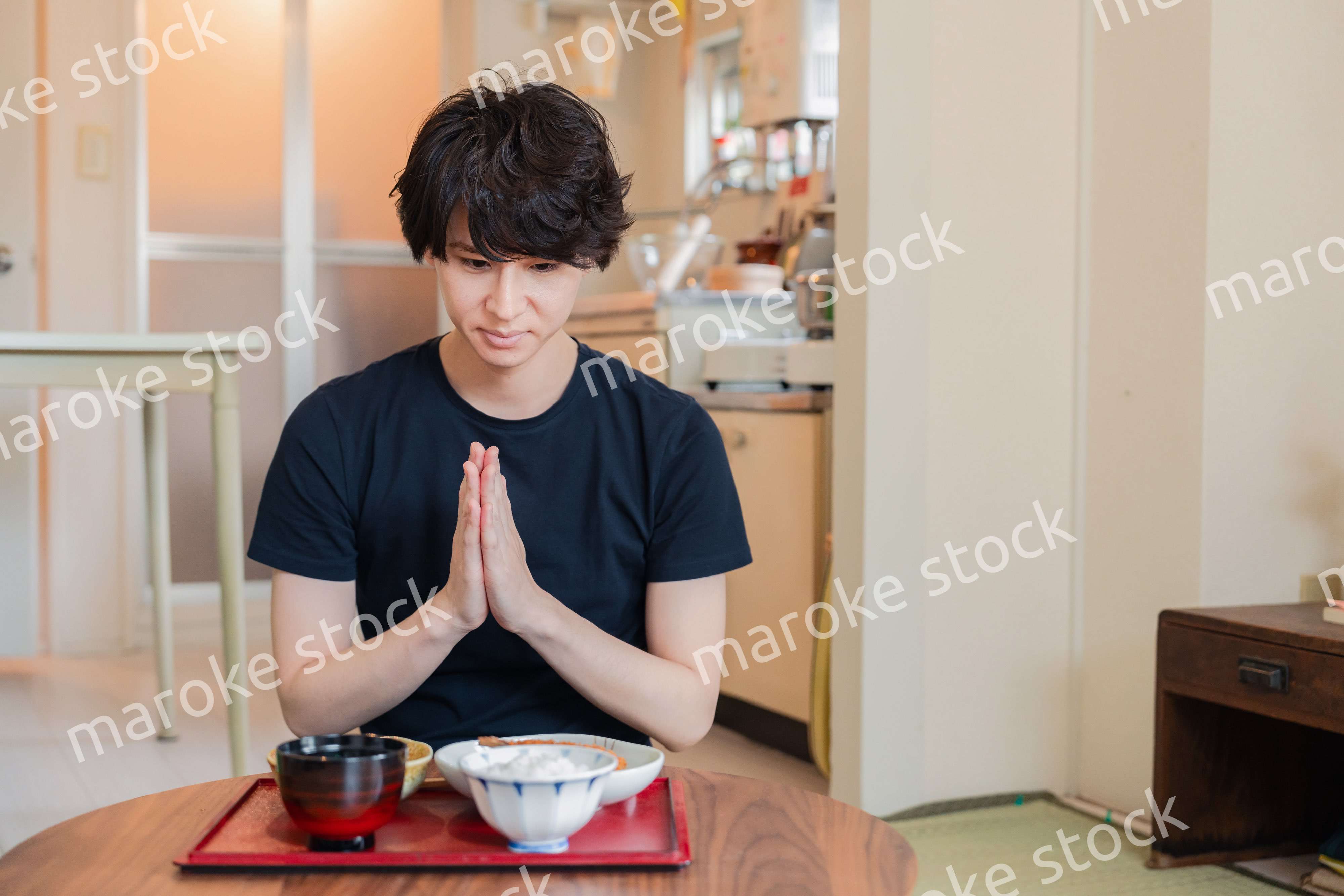 一人暮らしの下宿先でごはんを食べる若い男性