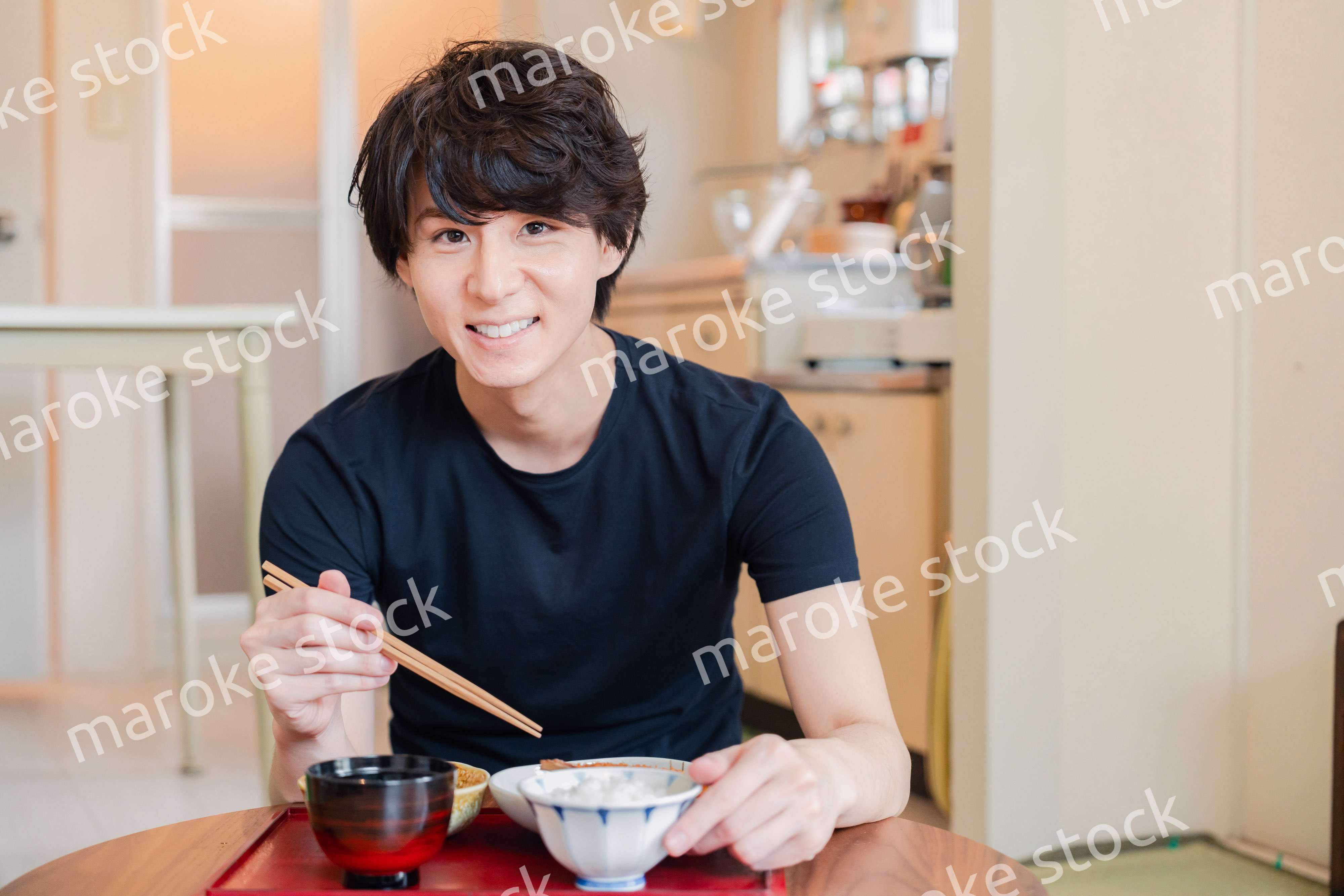 一人暮らしの下宿先でごはんを食べる若い男性