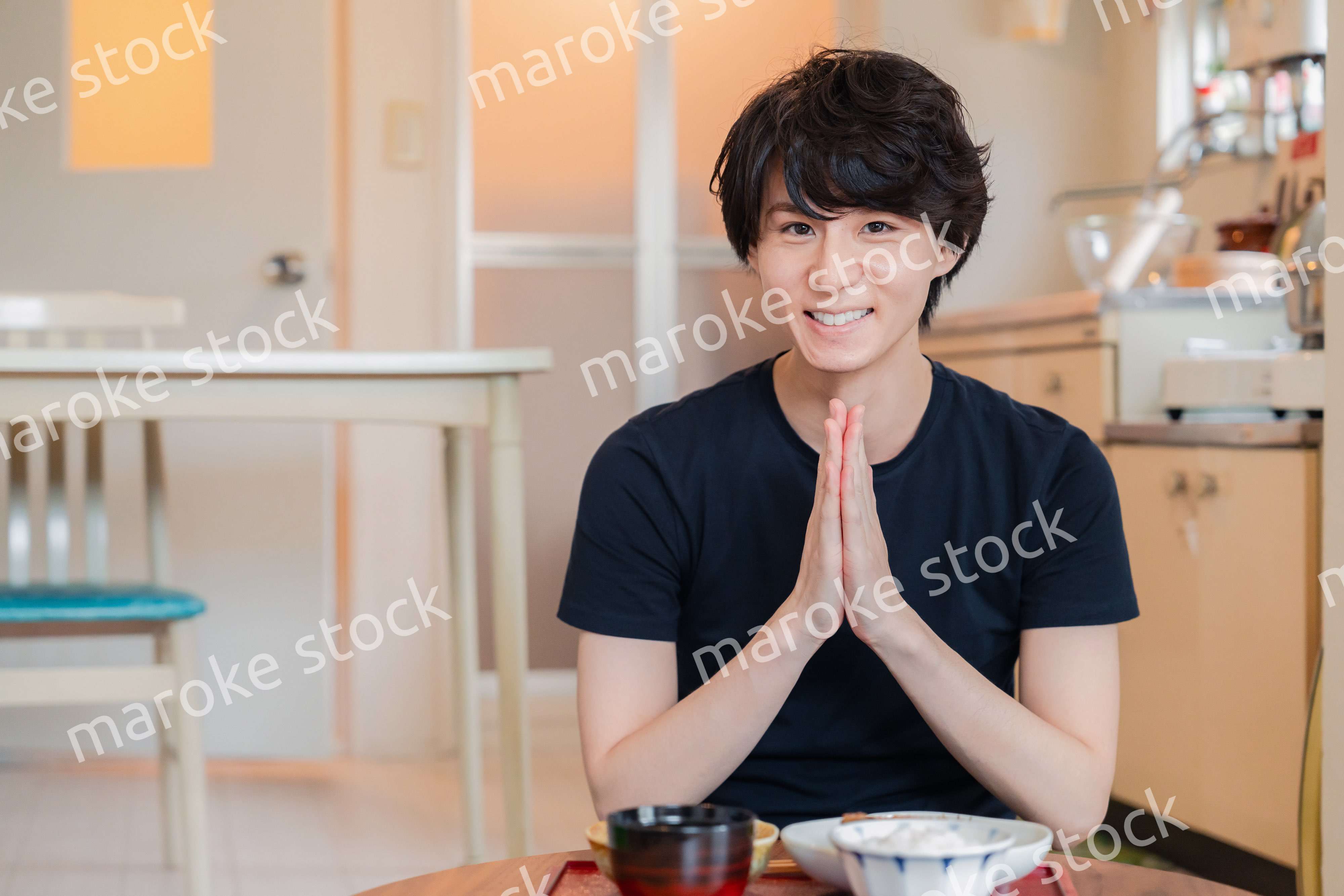 一人暮らしの下宿先でごはんを食べる若い男性