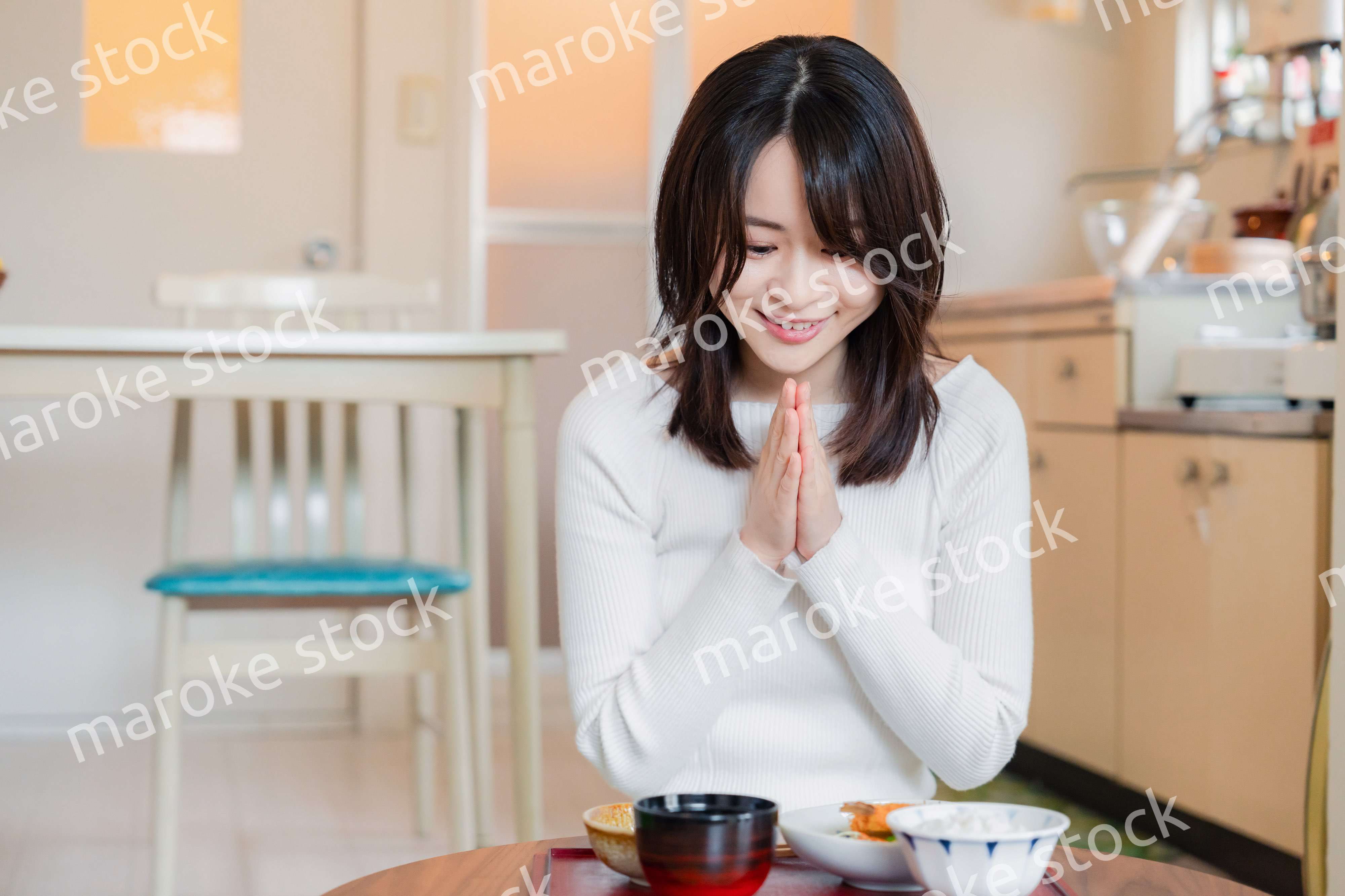 質素な家でごはんを食べる一人暮らしの女性