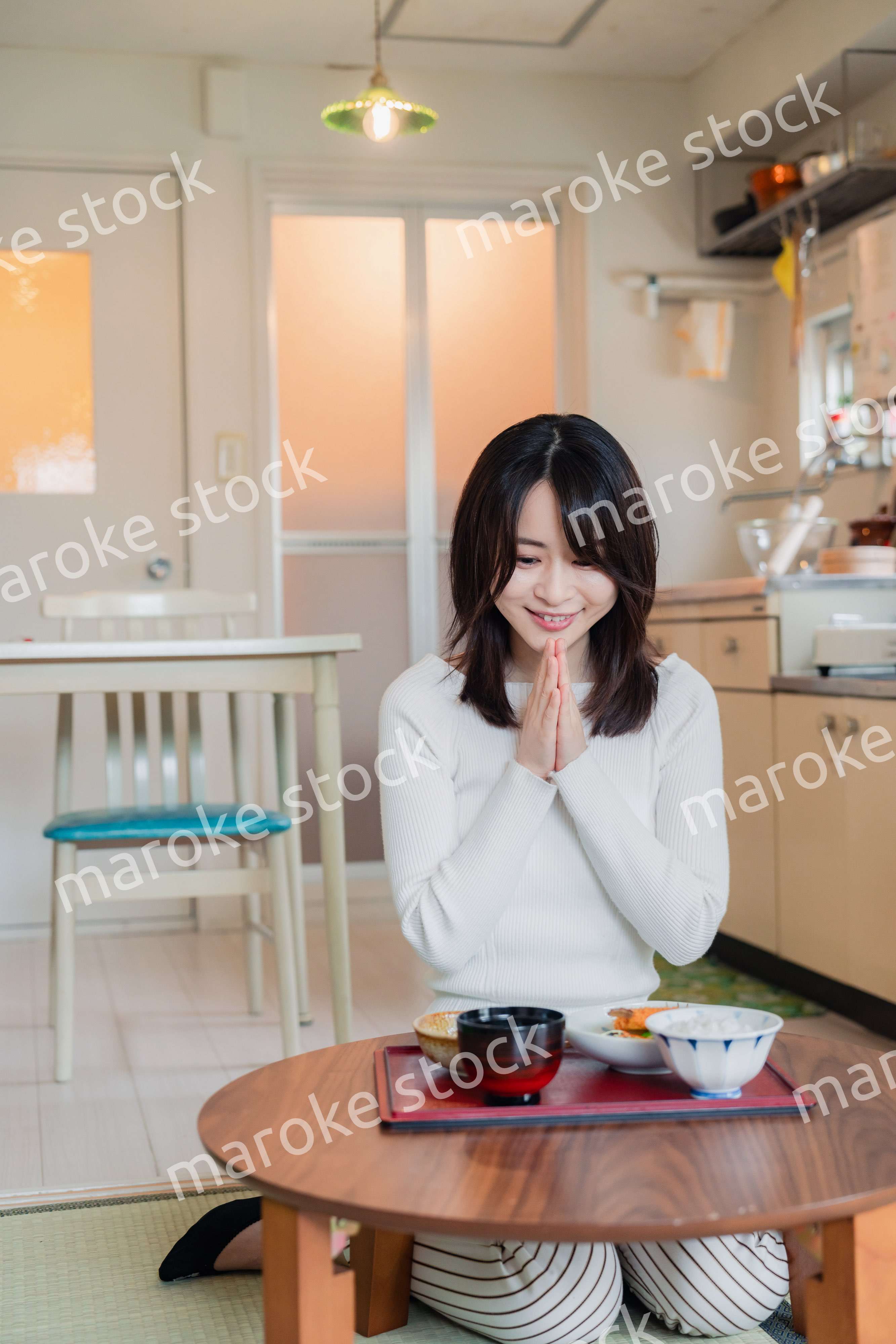 質素な家でごはんを食べる一人暮らしの女性