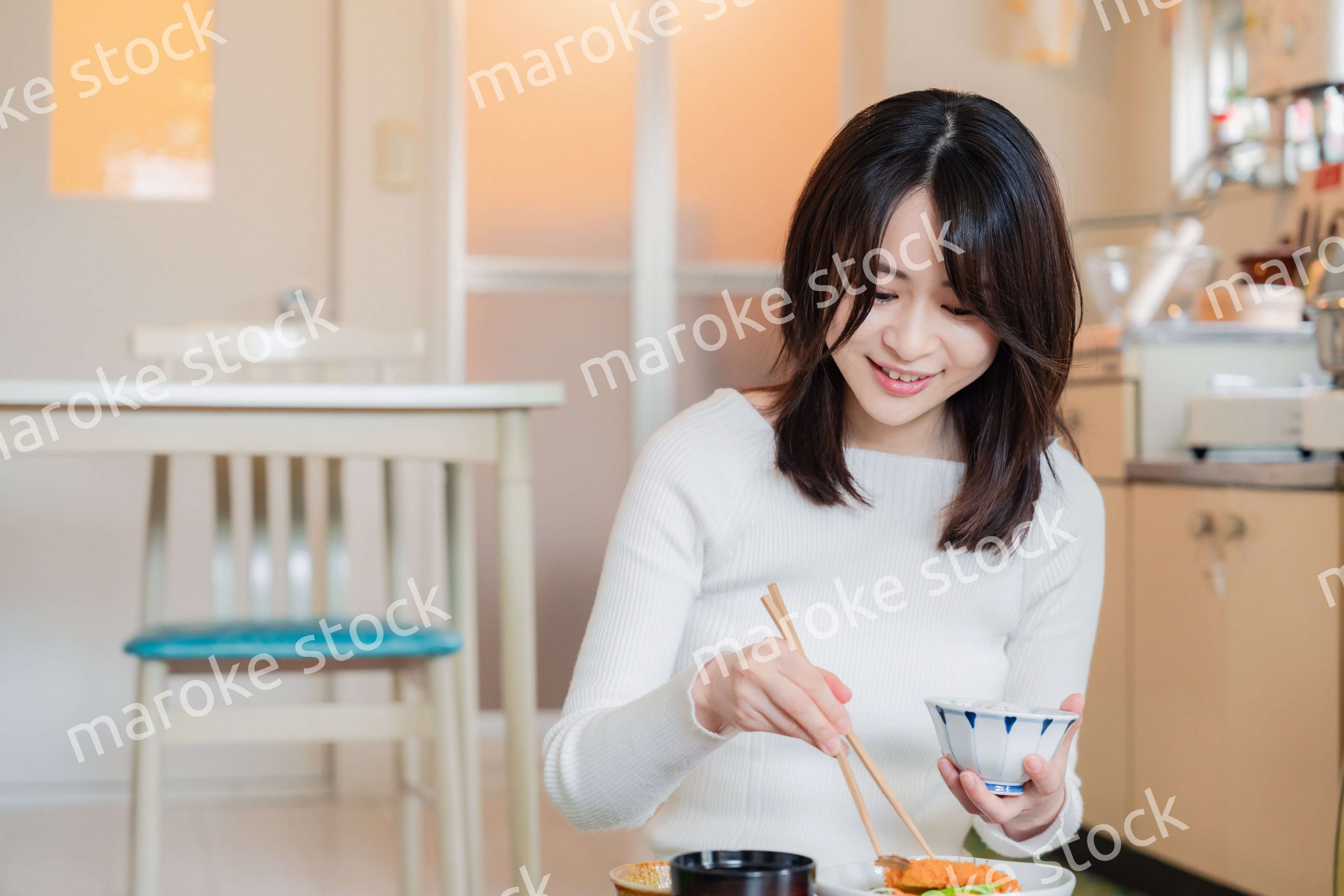 質素な家でごはんを食べる一人暮らしの女性