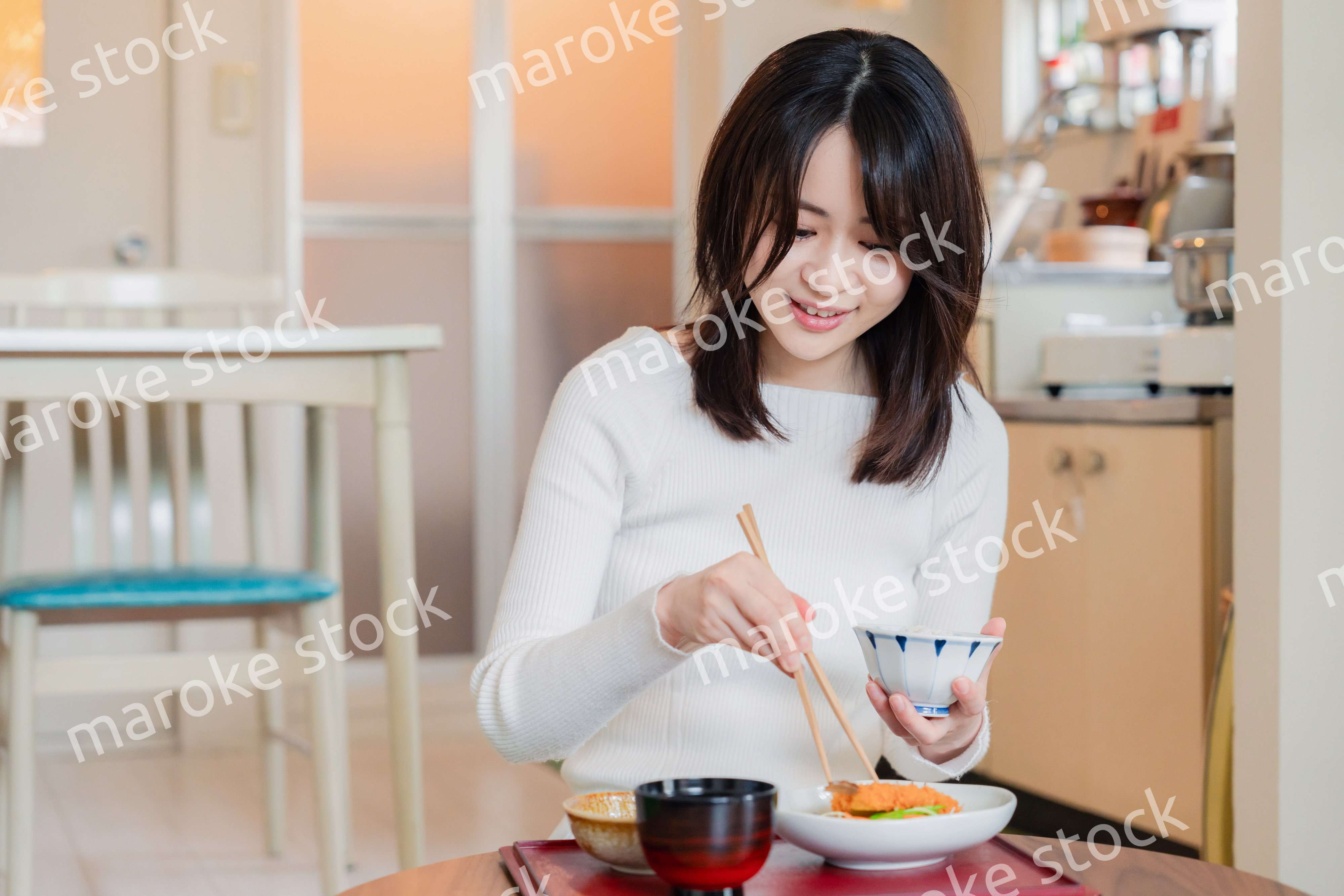 質素な家でごはんを食べる一人暮らしの女性