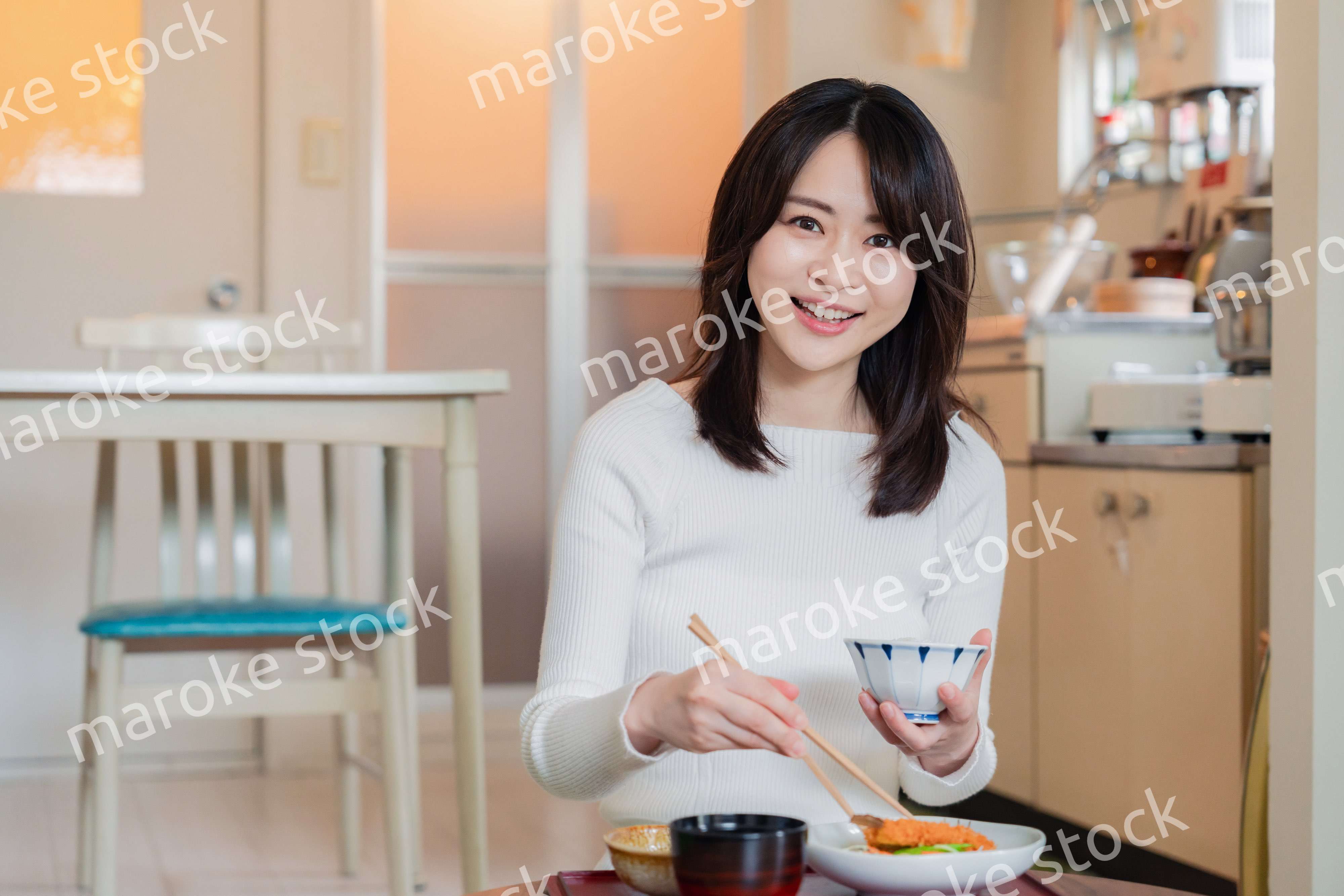 質素な家でごはんを食べる一人暮らしの女性