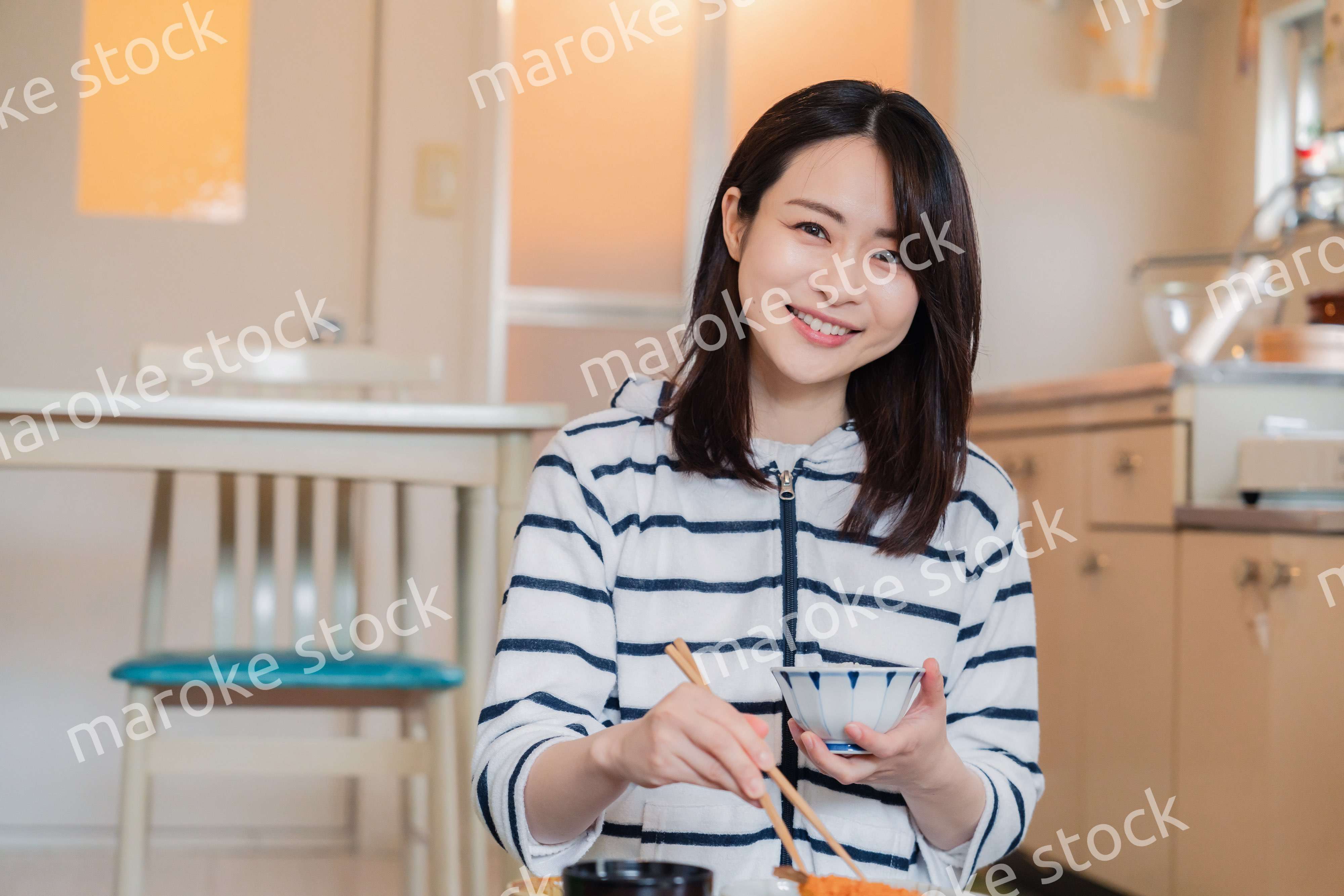 質素な家でごはんを食べる一人暮らしの女性