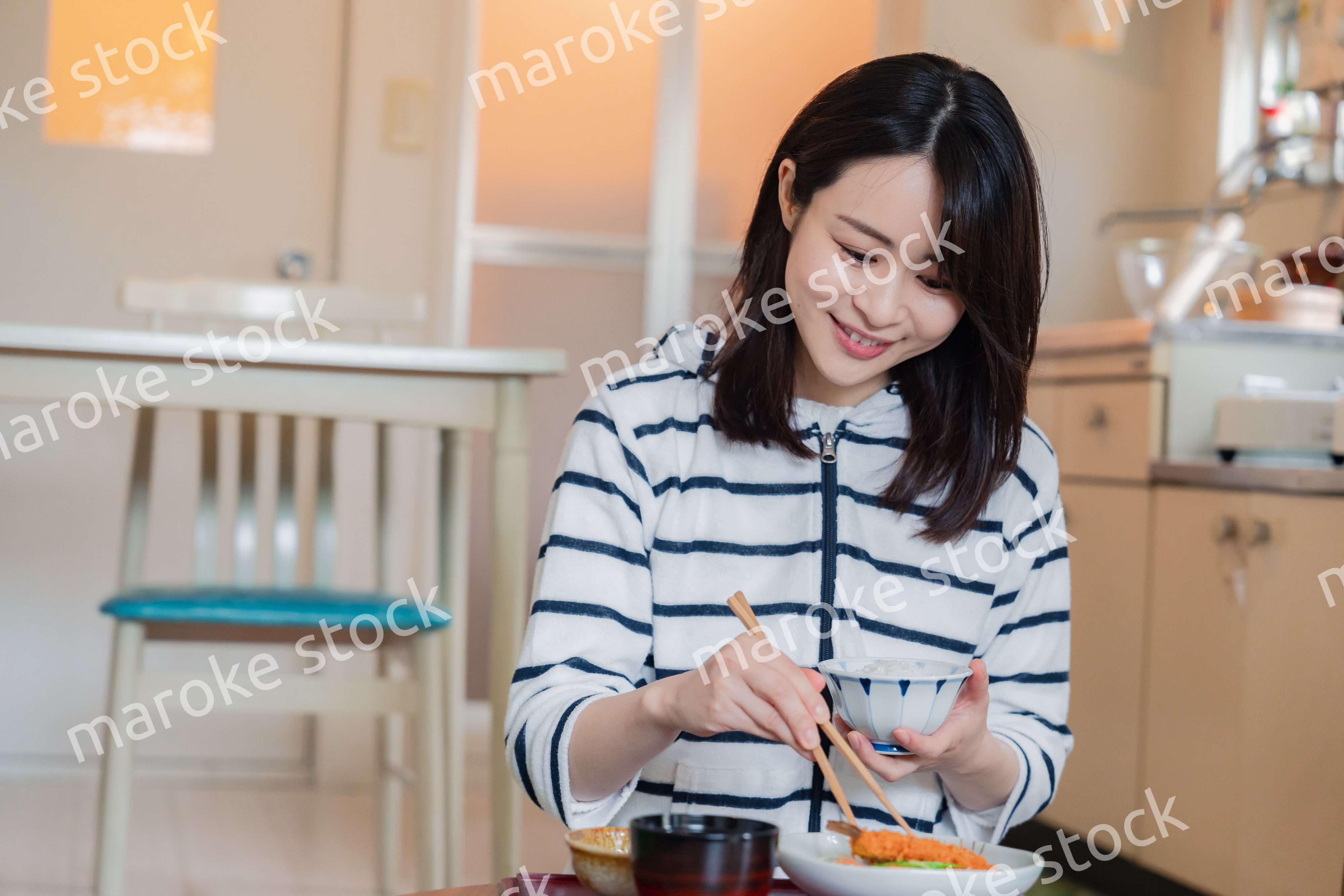 質素な家でごはんを食べる一人暮らしの女性